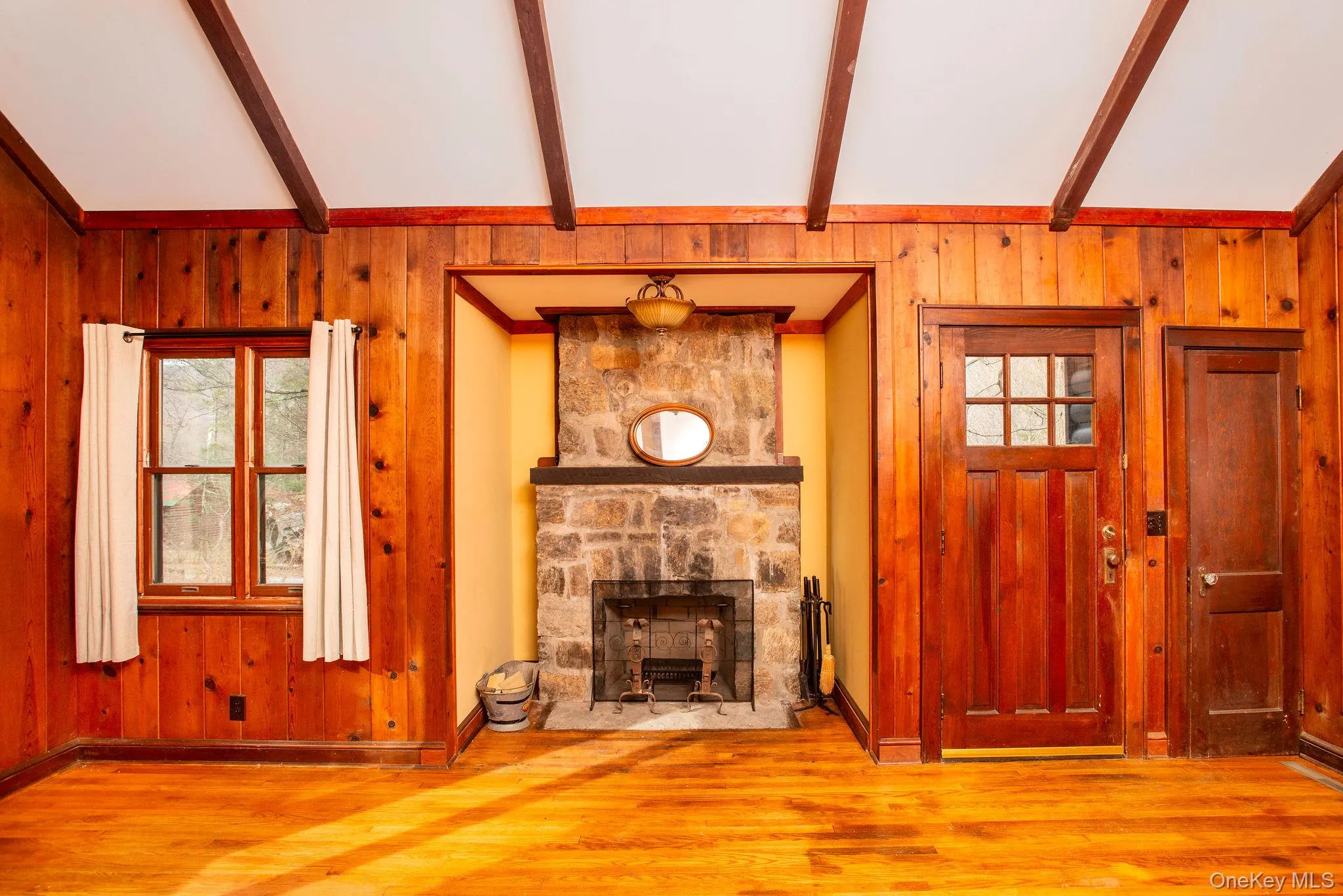 Carefully restored great room, with wood burning fireplace, wood paneling, tall ceilings and beams. Carefully restored great room, with wood burning fireplace, wood paneling, tall ceilings and beams.