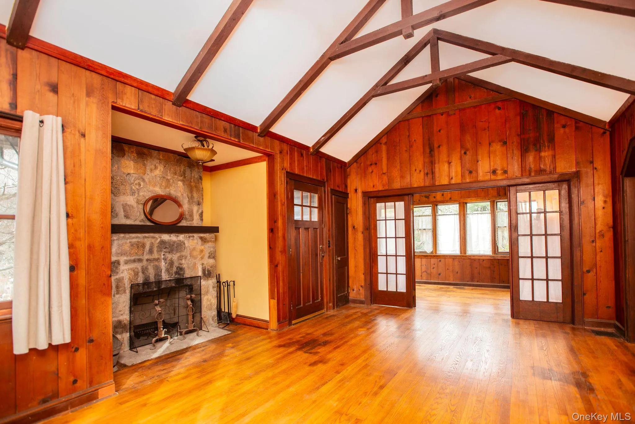 Carefully restored great room, with wood burning fireplace, wood paneling, tall ceilings and beams. Carefully restored great room, with wood burning fireplace, wood paneling, tall ceilings and beams.