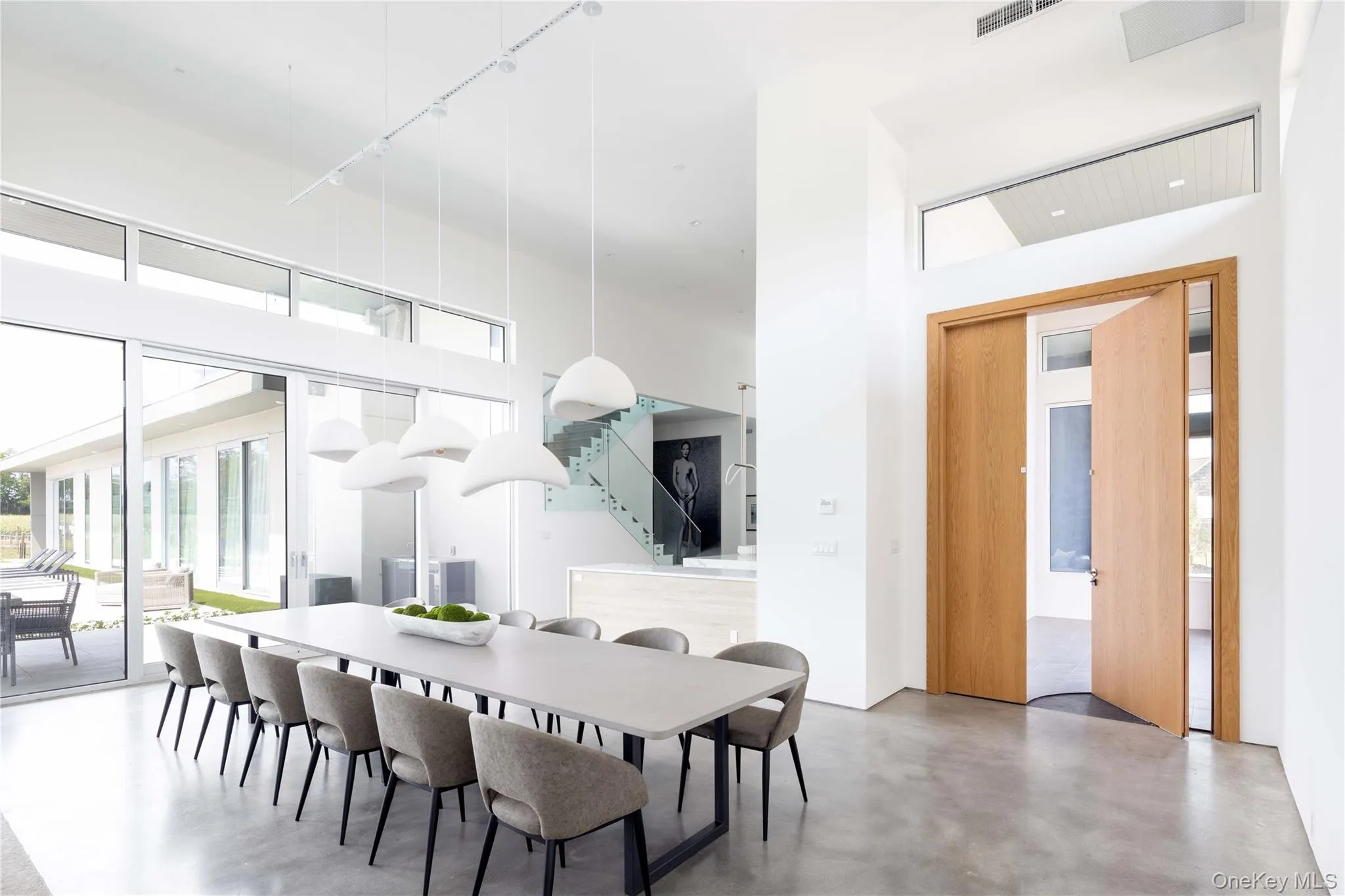 Dining area with concrete flooring, a towering ceiling, and track lighting Dining area with concrete flooring, a towering ceiling, and track lighting
