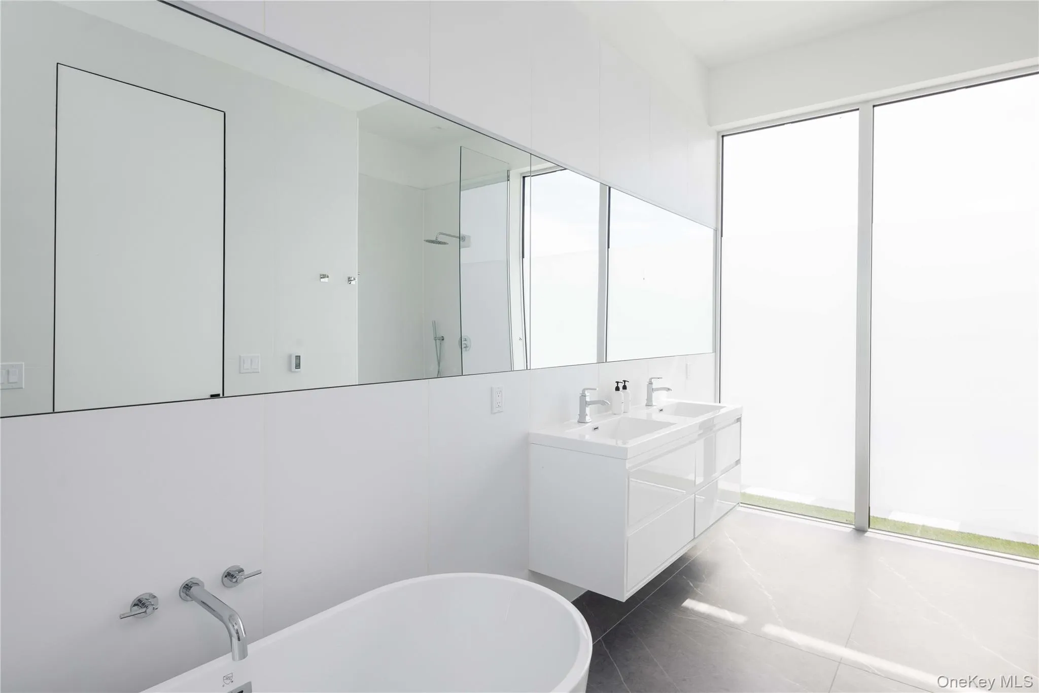 Bathroom featuring tile patterned floors, a tub to relax in, and vanity Bathroom featuring tile patterned floors, a tub to relax in, and vanity