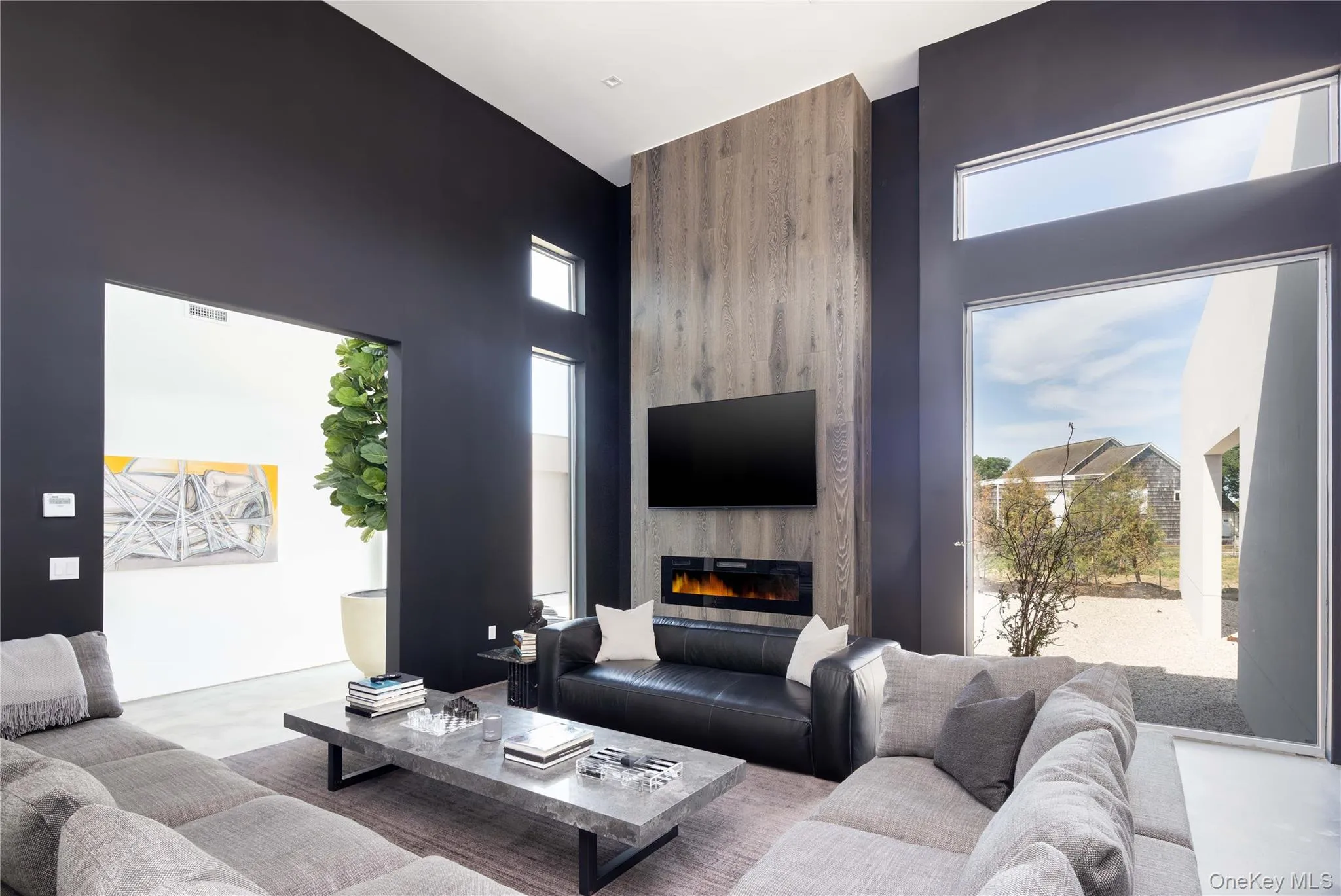 Living room featuring a towering ceiling and a fireplace Living room featuring a towering ceiling and a fireplace