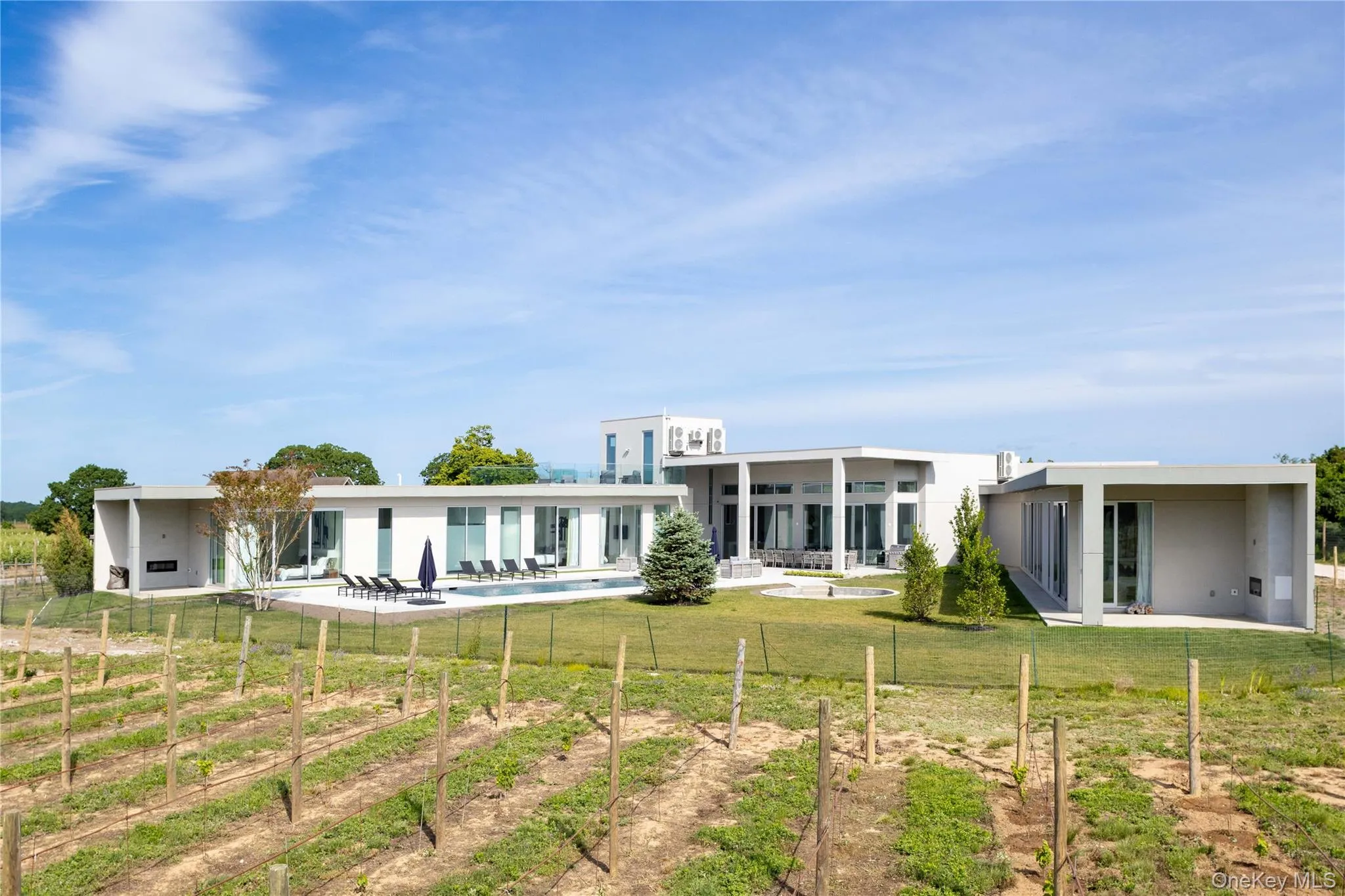 Back of property featuring a lawn, a rural view, and a patio Back of property featuring a lawn, a rural view, and a patio
