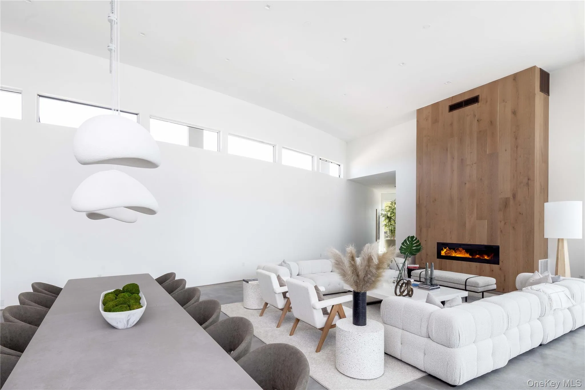 Living room featuring a fireplace, a high ceiling, and a healthy amount of sunlight Living room featuring a fireplace, a high ceiling, and a healthy amount of sunlight