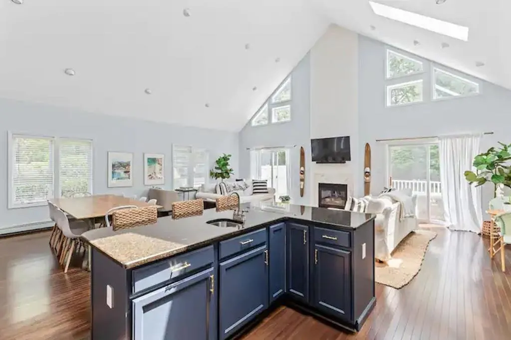 Kitchen featuring dark hardwood / wood-style flooring, high vaulted ceiling, plenty of natural light, and a kitchen island with sink Kitchen featuring dark hardwood / wood-style flooring, high vaulted ceiling, plenty of natural light, and a kitchen island with sink
