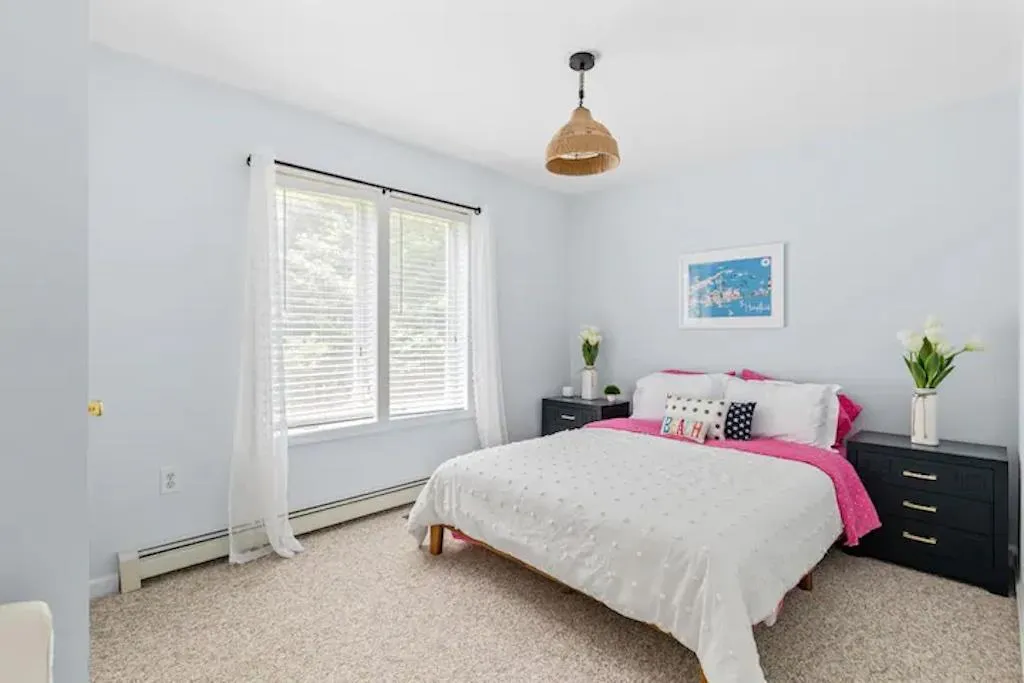 Bedroom with light carpet and baseboard heating Bedroom with light carpet and baseboard heating