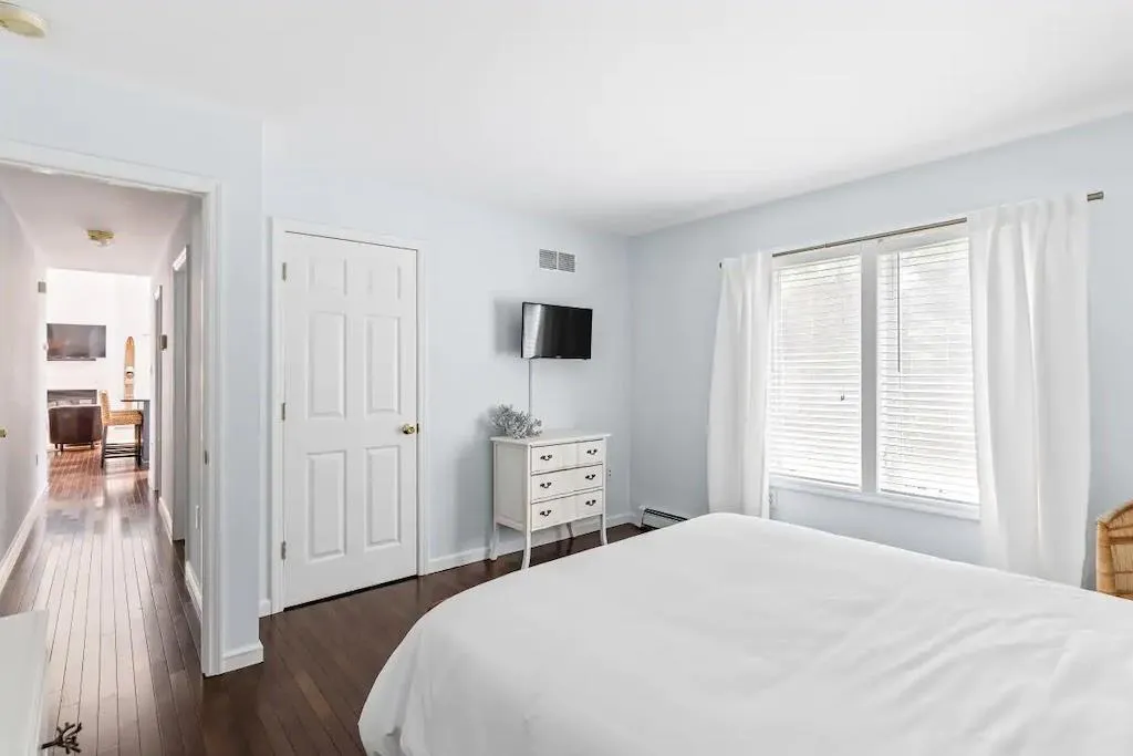 Bedroom featuring a fireplace, dark hardwood / wood-style floors, and baseboard heating Bedroom featuring a fireplace, dark hardwood / wood-style floors, and baseboard heating