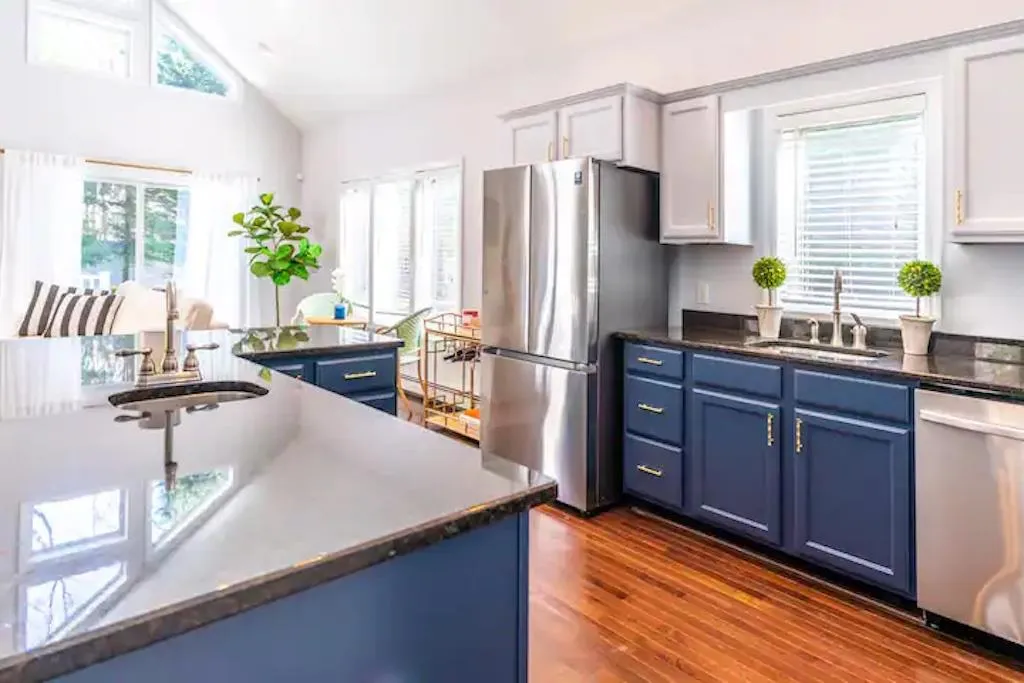 Kitchen with blue cabinetry, dark hardwood / wood-style floors, sink, and appliances with stainless steel finishes Kitchen with blue cabinetry, dark hardwood / wood-style floors, sink, and appliances with stainless steel finishes