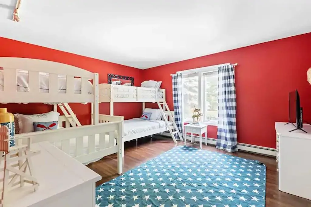 Bedroom with dark hardwood / wood-style floors and a baseboard heating unit Bedroom with dark hardwood / wood-style floors and a baseboard heating unit