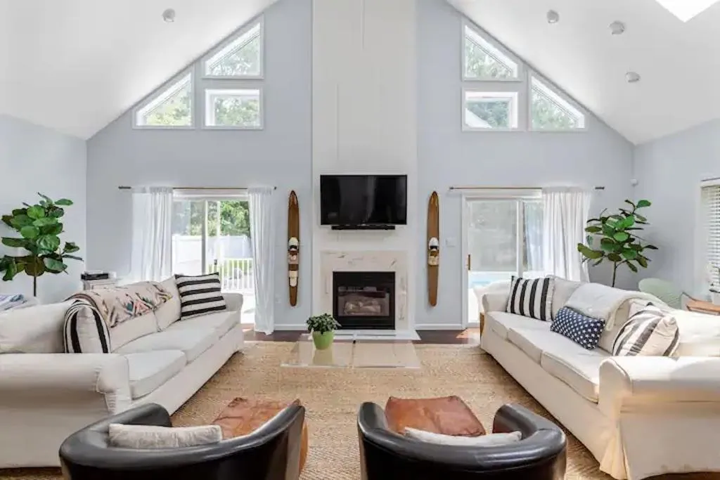 Living room featuring light wood-type flooring and high vaulted ceiling Living room featuring light wood-type flooring and high vaulted ceiling