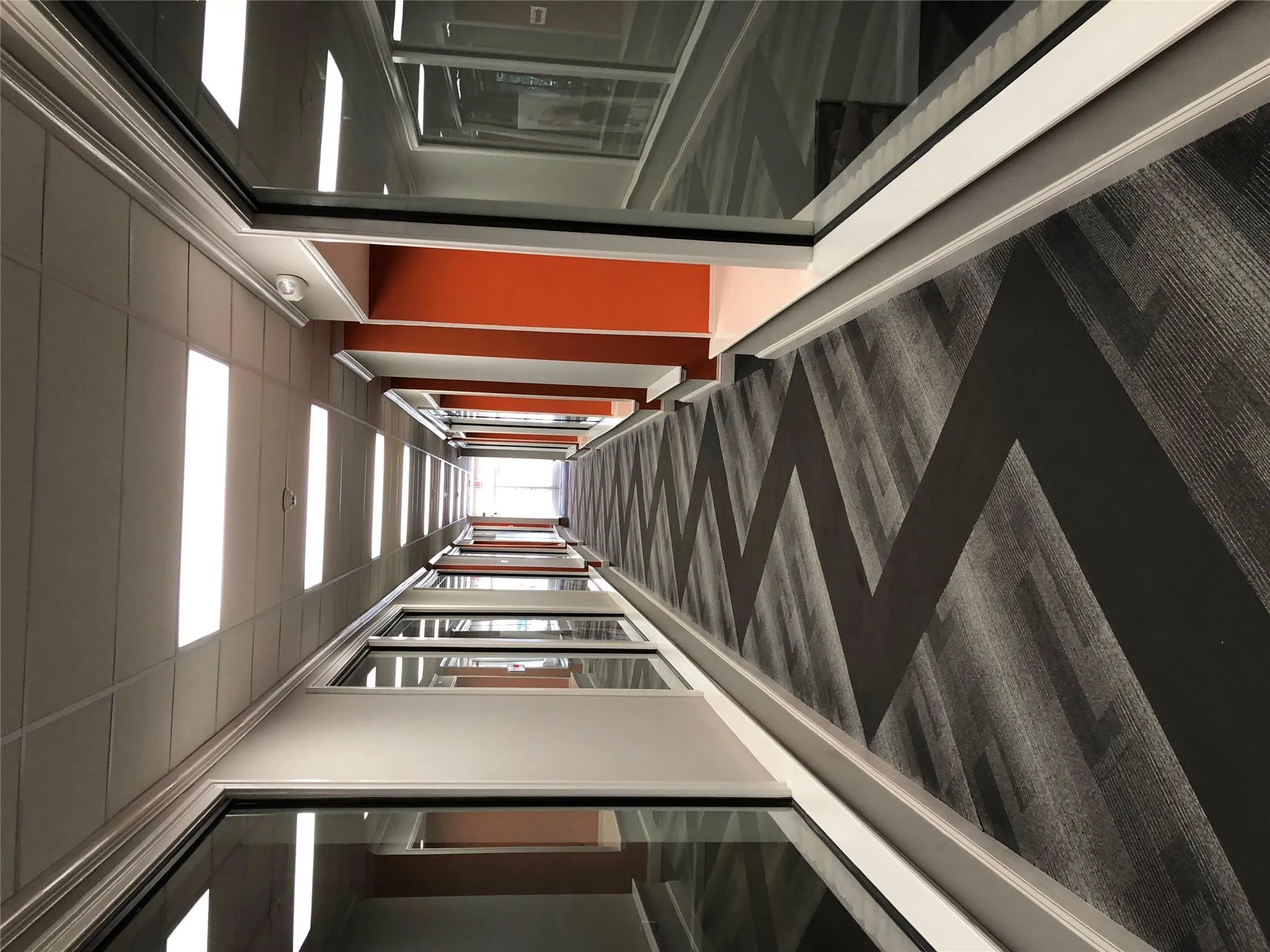 Corridor featuring dark carpet and a drop ceiling Corridor featuring dark carpet and a drop ceiling