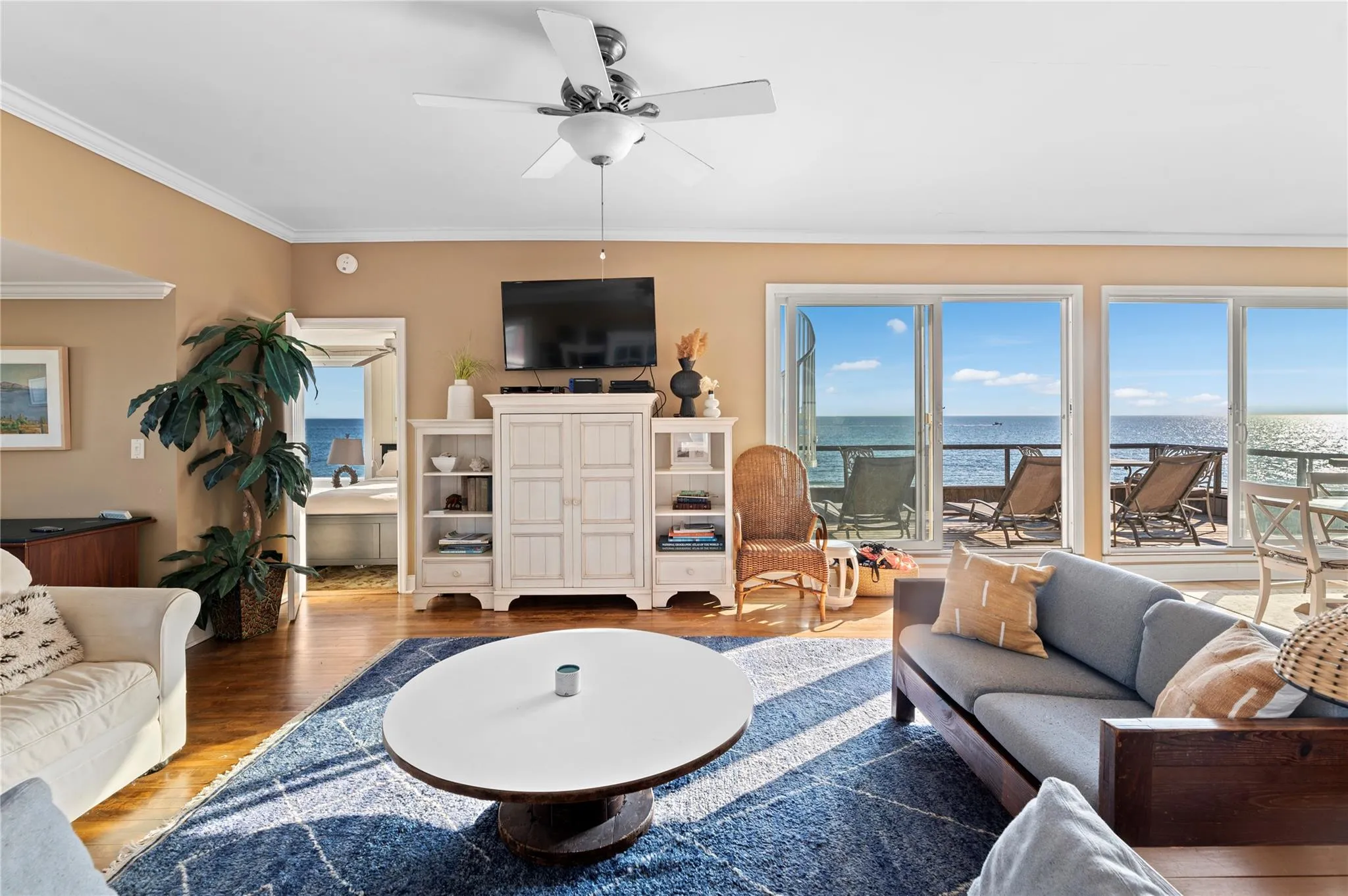 Living room with hardwood / wood-style floors, ceiling fan, and crown molding Living room with hardwood / wood-style floors, ceiling fan, and crown molding
