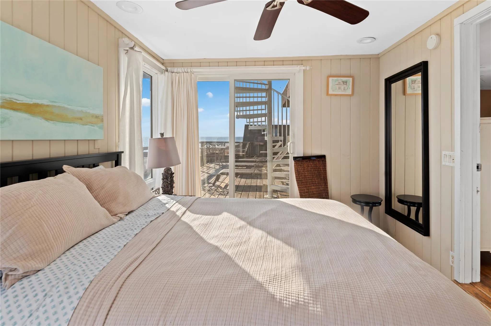 Bedroom with access to exterior, hardwood / wood-style flooring, ceiling fan, and wooden walls Bedroom with access to exterior, hardwood / wood-style flooring, ceiling fan, and wooden walls