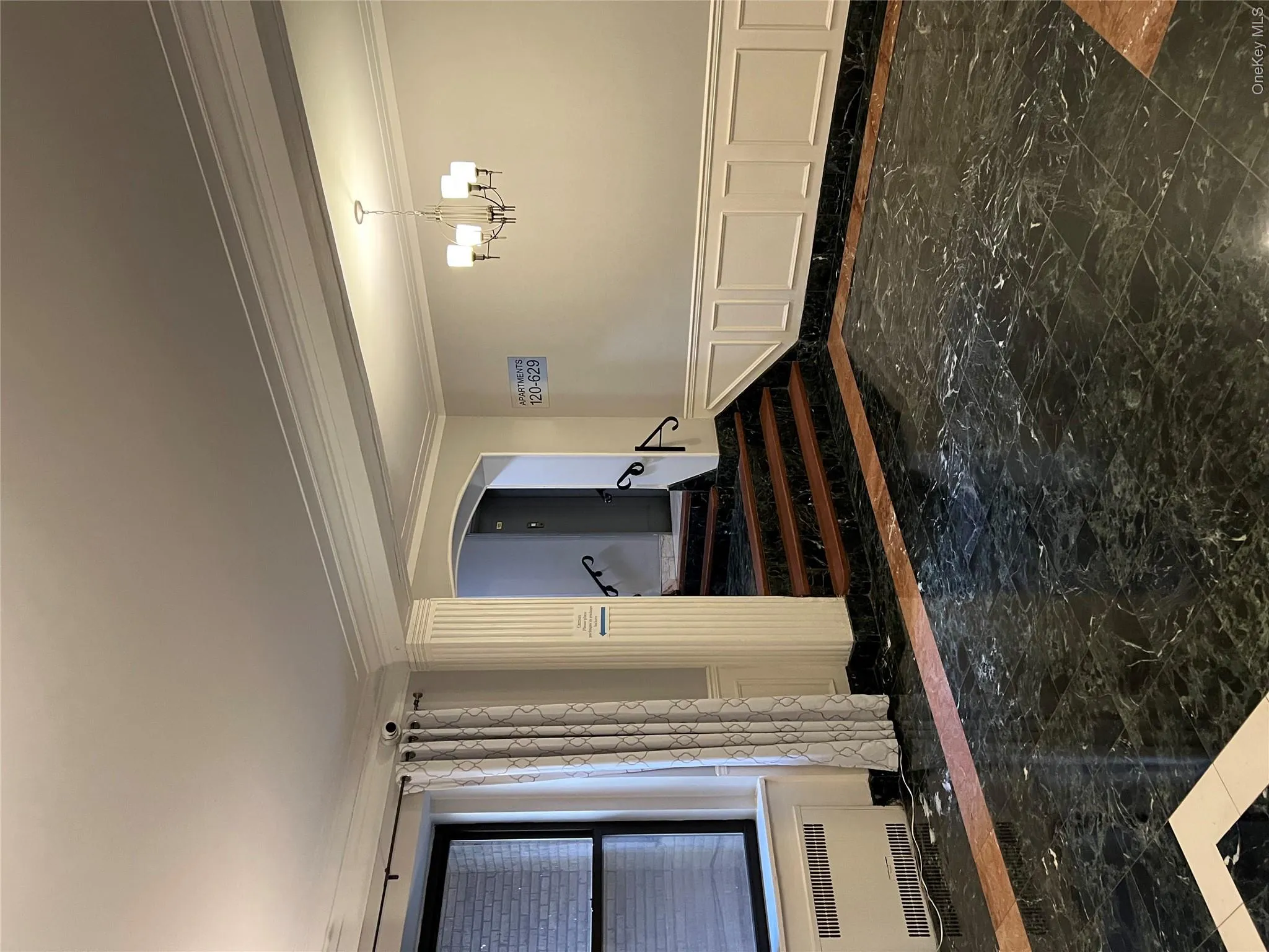 Unfurnished room with crown molding, radiator heating unit, and an inviting chandelier Unfurnished room with crown molding, radiator heating unit, and an inviting chandelier