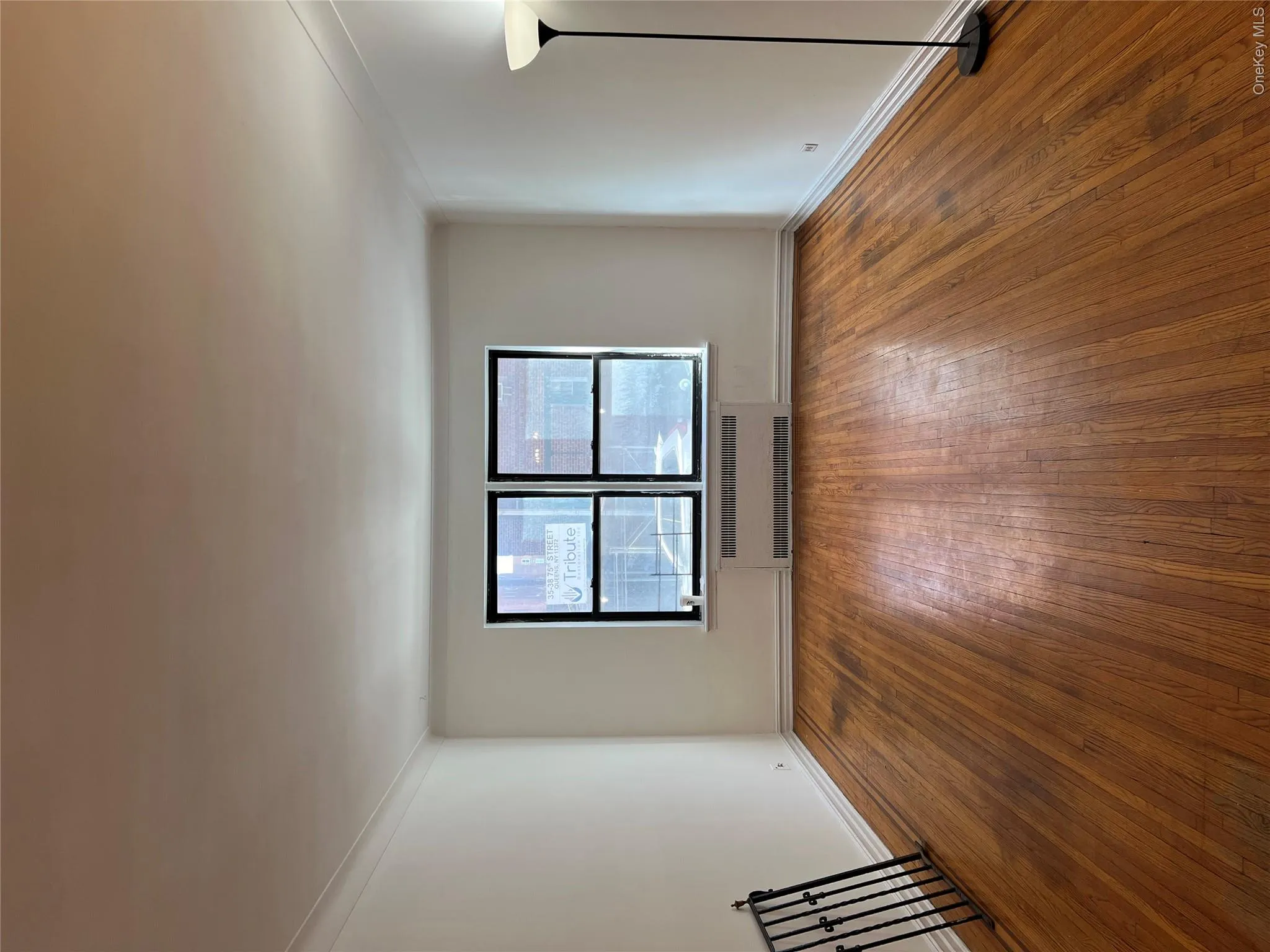 Empty room featuring dark hardwood / wood-style flooring, radiator, and ornamental molding Empty room featuring dark hardwood / wood-style flooring, radiator, and ornamental molding