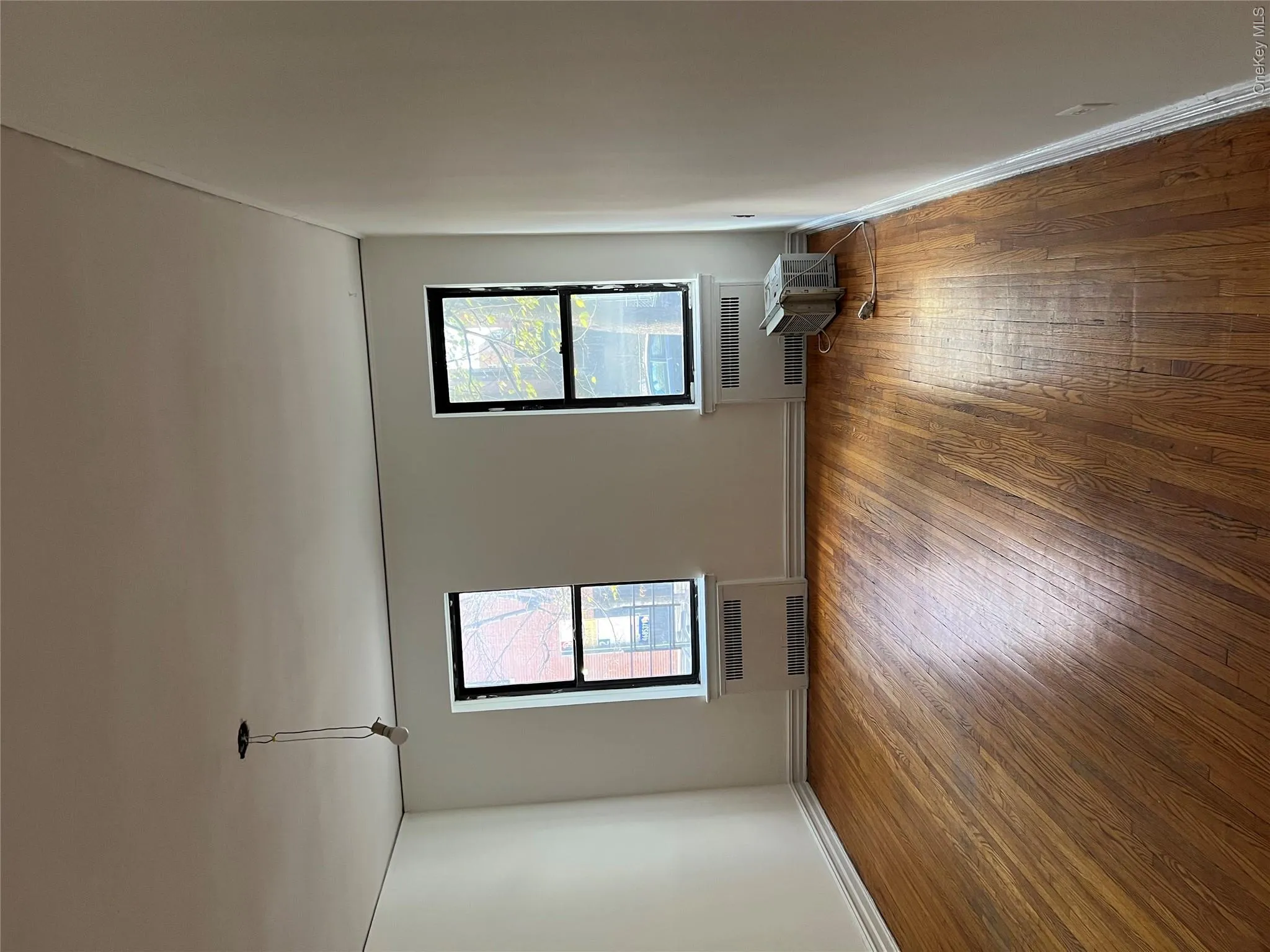 Spare room with radiator, dark hardwood / wood-style flooring, and a healthy amount of sunlight Spare room with radiator, dark hardwood / wood-style flooring, and a healthy amount of sunlight