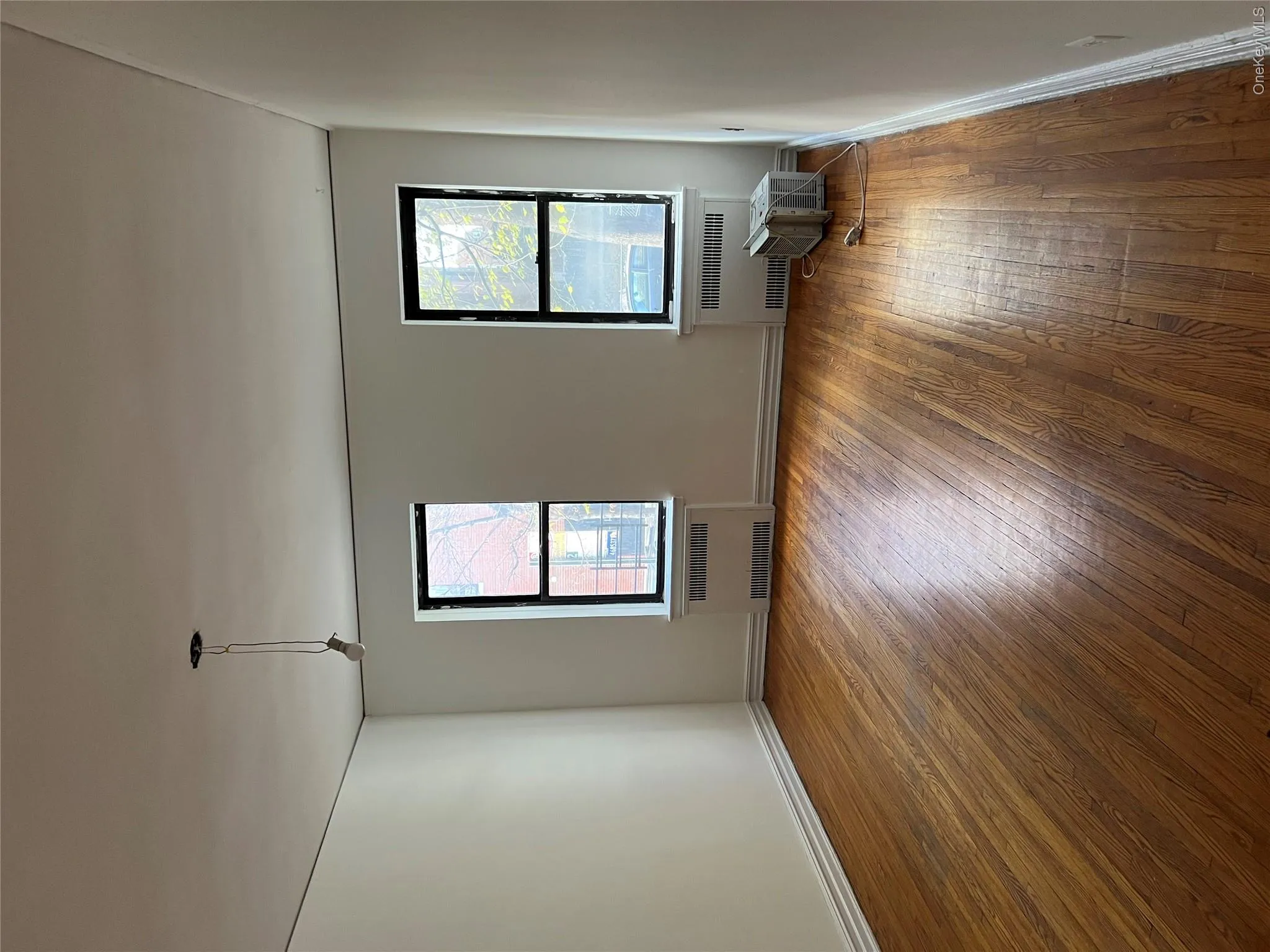 Spare room with radiator and dark hardwood / wood-style flooring Spare room with radiator and dark hardwood / wood-style flooring