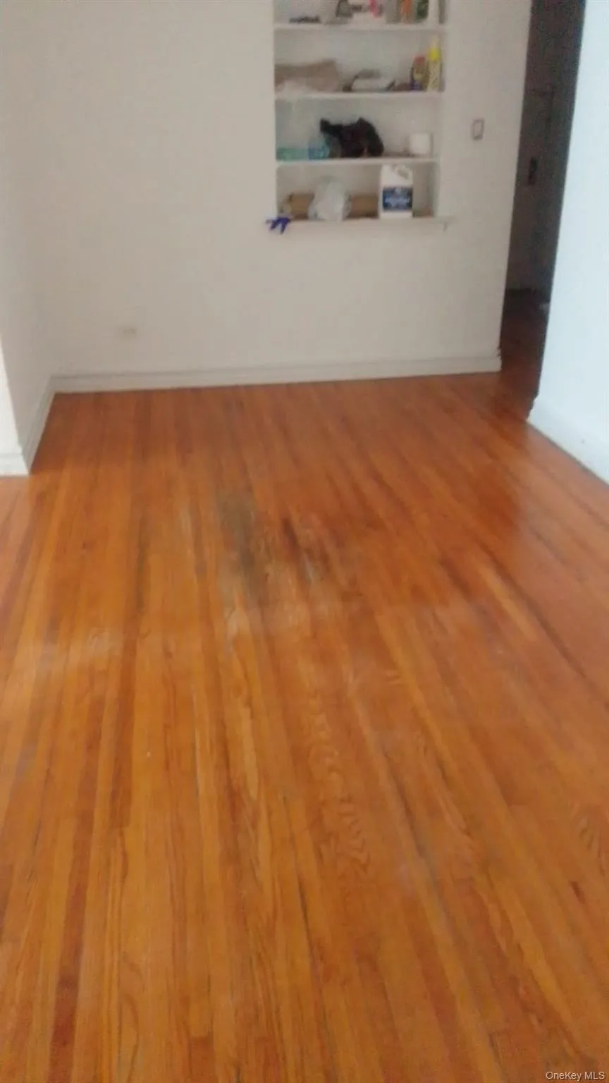 Unfurnished room with wood finished floors and baseboards Unfurnished room with wood finished floors and baseboards