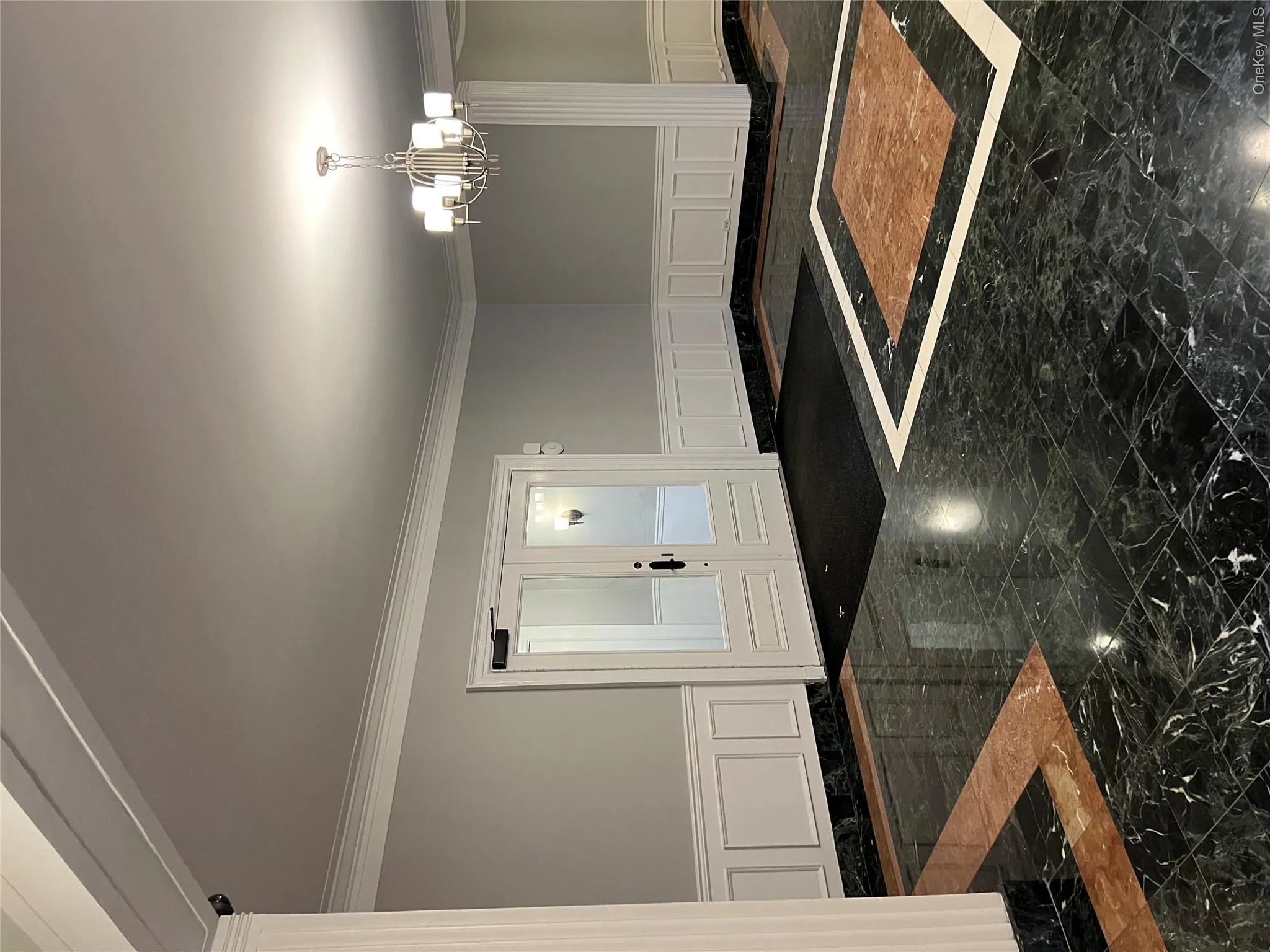 Foyer entrance featuring an inviting chandelier and ornamental molding Foyer entrance featuring an inviting chandelier and ornamental molding