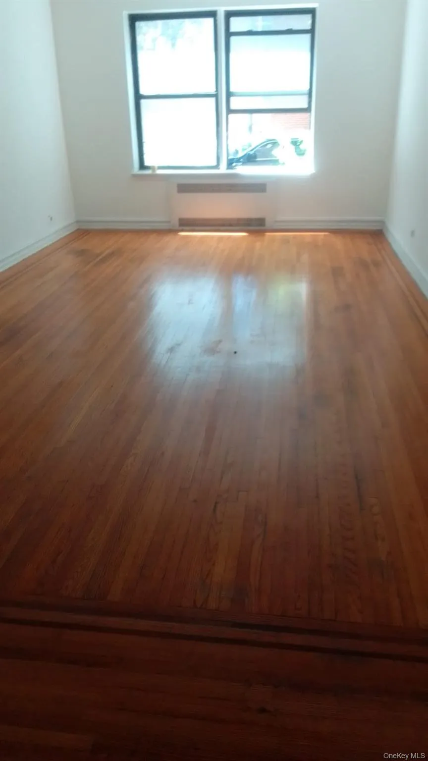 Unfurnished room with plenty of natural light and wood finished floors Unfurnished room with plenty of natural light and wood finished floors