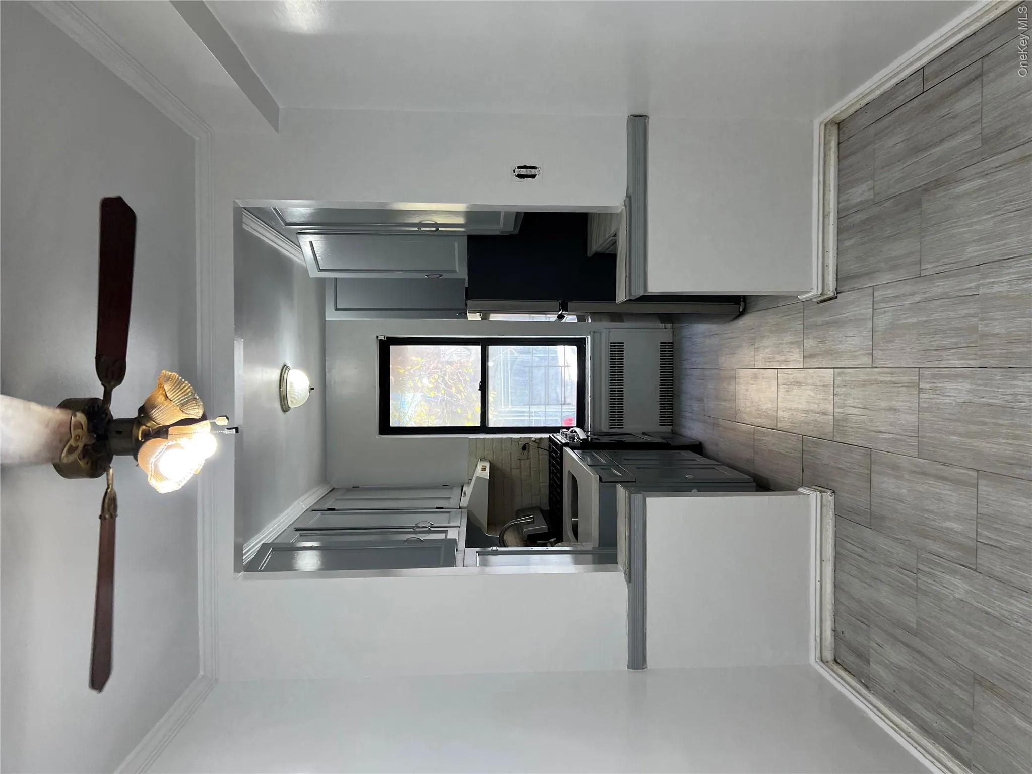 Kitchen with backsplash, gray cabinets, and radiator Kitchen with backsplash, gray cabinets, and radiator