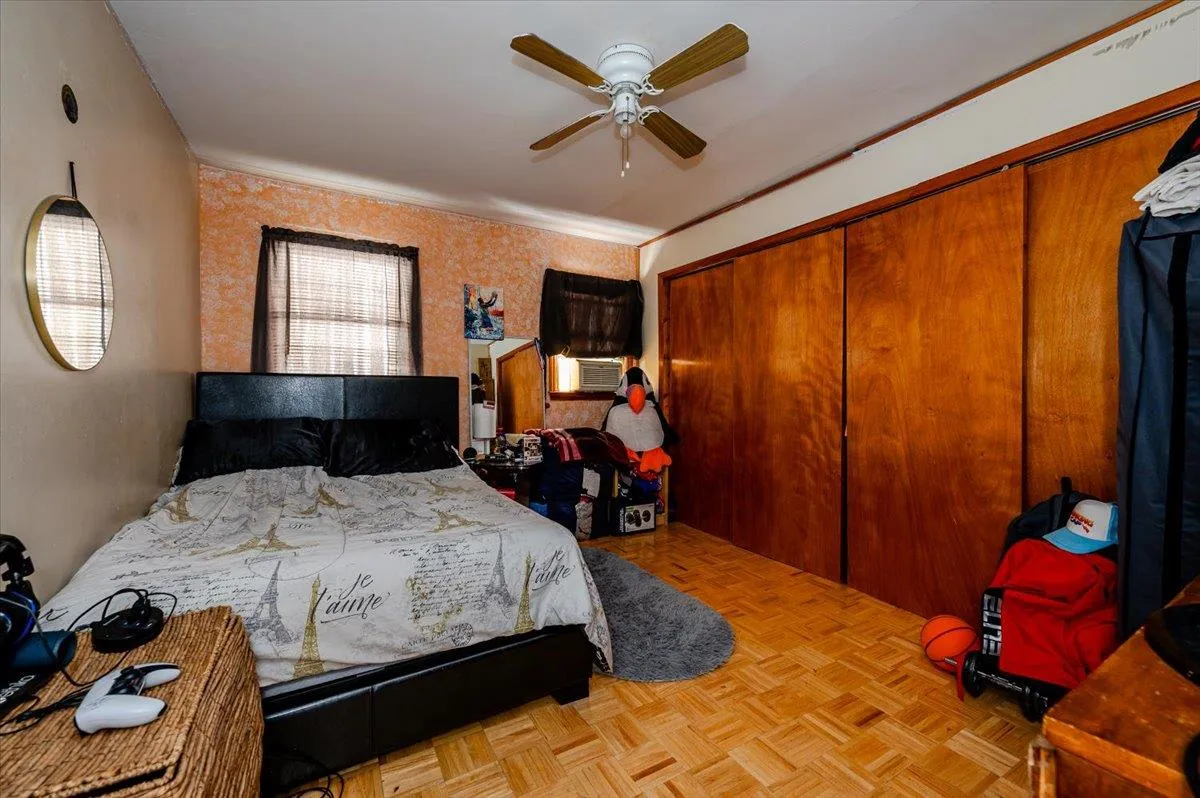 Bedroom featuring light parquet flooring, a closet, ceiling fan, and crown molding Bedroom featuring light parquet flooring, a closet, ceiling fan, and crown molding