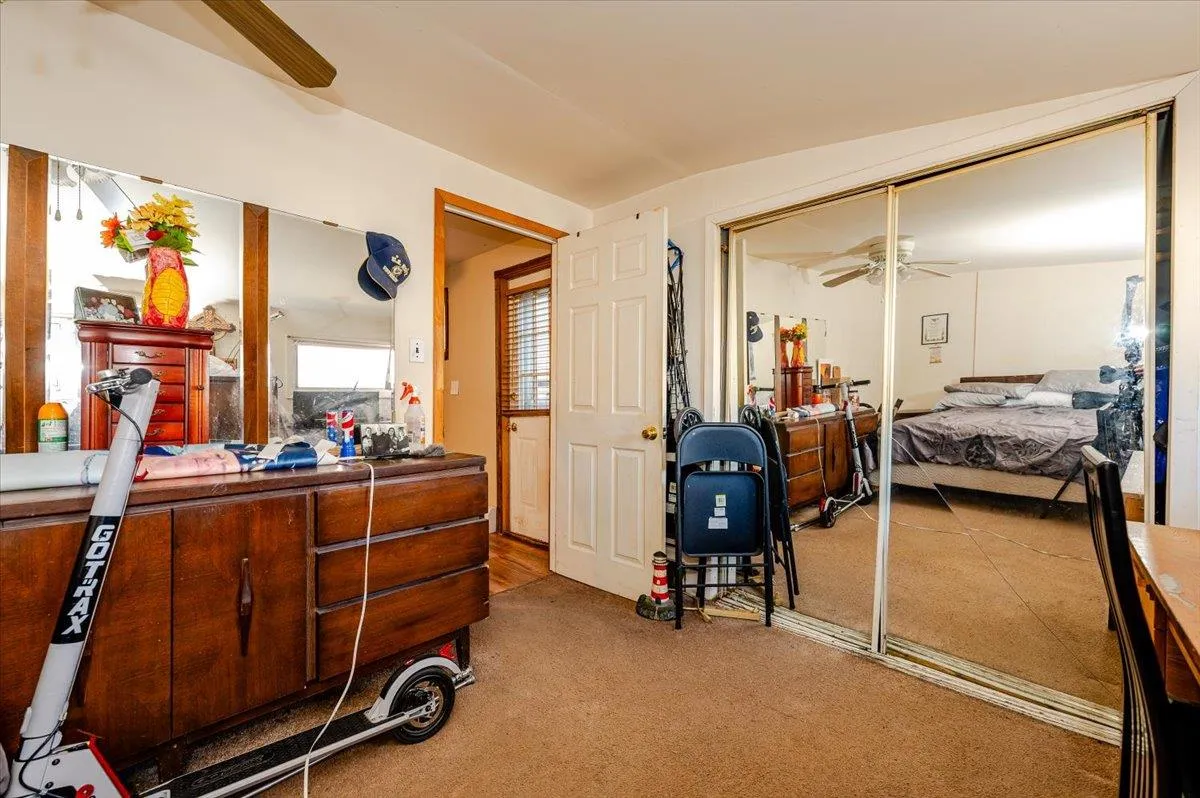 Carpeted bedroom with a closet and ceiling fan Carpeted bedroom with a closet and ceiling fan