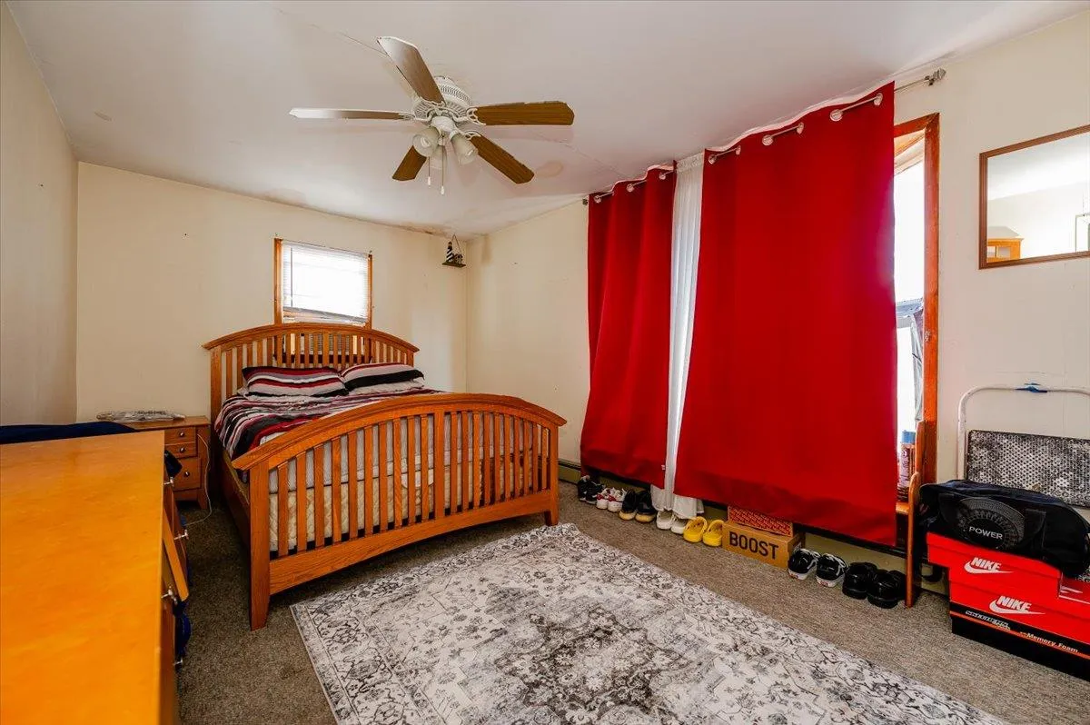 Carpeted bedroom featuring ceiling fan Carpeted bedroom featuring ceiling fan