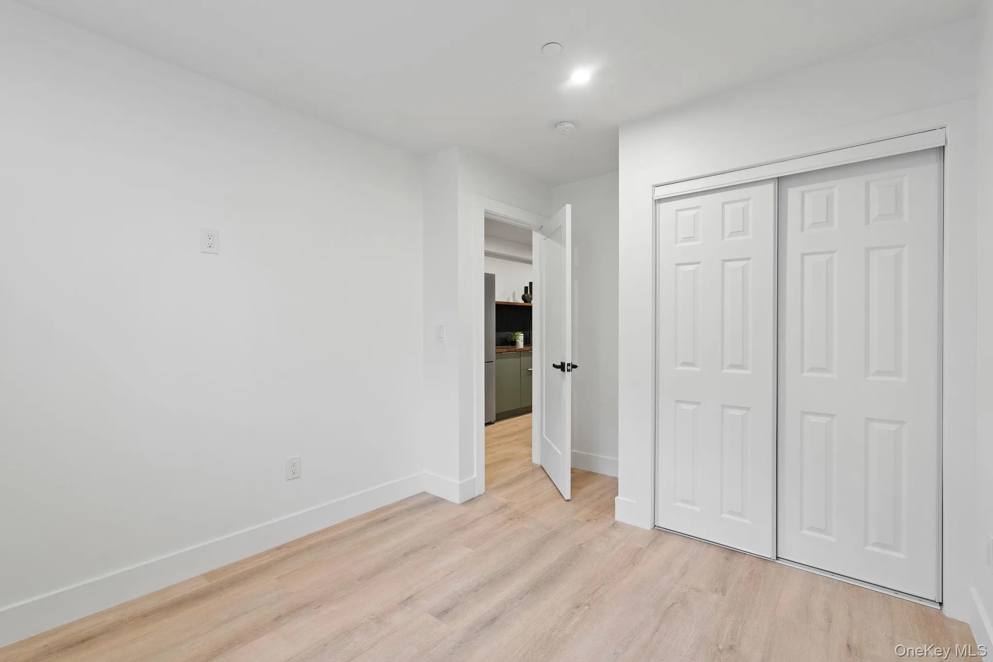 Unfurnished bedroom with a closet and light hardwood / wood-style floors Unfurnished bedroom with a closet and light hardwood / wood-style floors