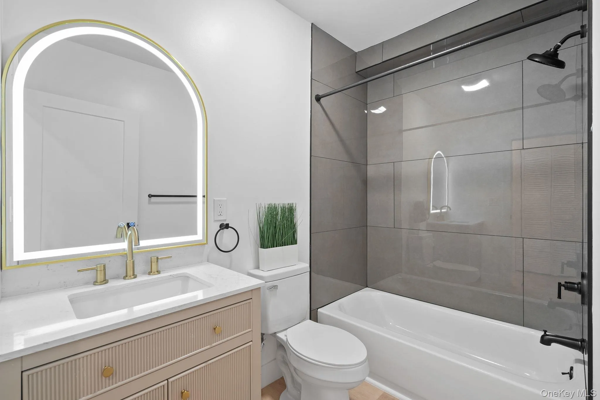 Full bathroom featuring tiled shower / bath combo, toilet, and vanity Full bathroom featuring tiled shower / bath combo, toilet, and vanity