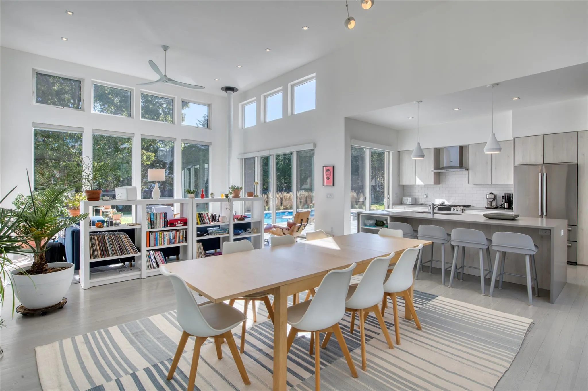 Dining room with ceiling fan, light hardwood / wood-style flooring, a towering ceiling, and sink Dining room with ceiling fan, light hardwood / wood-style flooring, a towering ceiling, and sink
