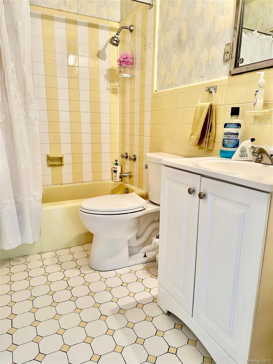 Full bathroom featuring vanity, shower / bathtub combination with curtain, tile walls, and toilet Full bathroom featuring vanity, shower / bathtub combination with curtain, tile walls, and toilet