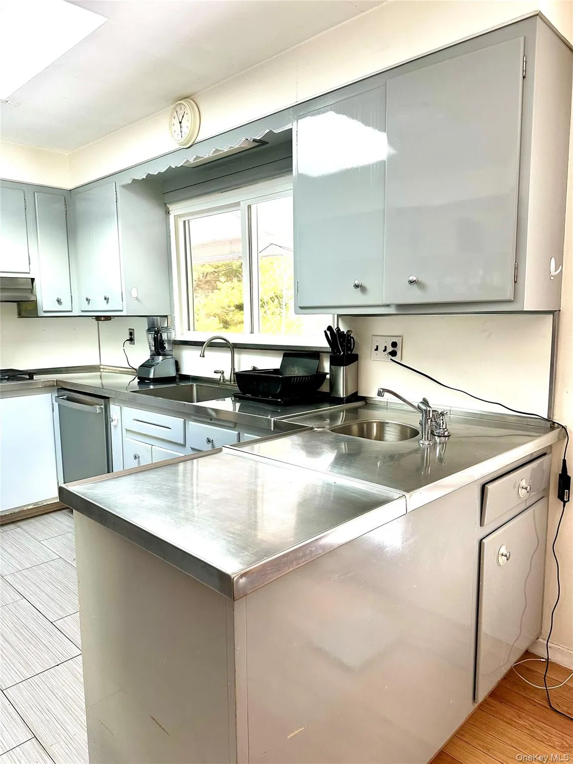 Kitchen with gray cabinetry, sink, light hardwood / wood-style flooring, and ventilation hood Kitchen with gray cabinetry, sink, light hardwood / wood-style flooring, and ventilation hood