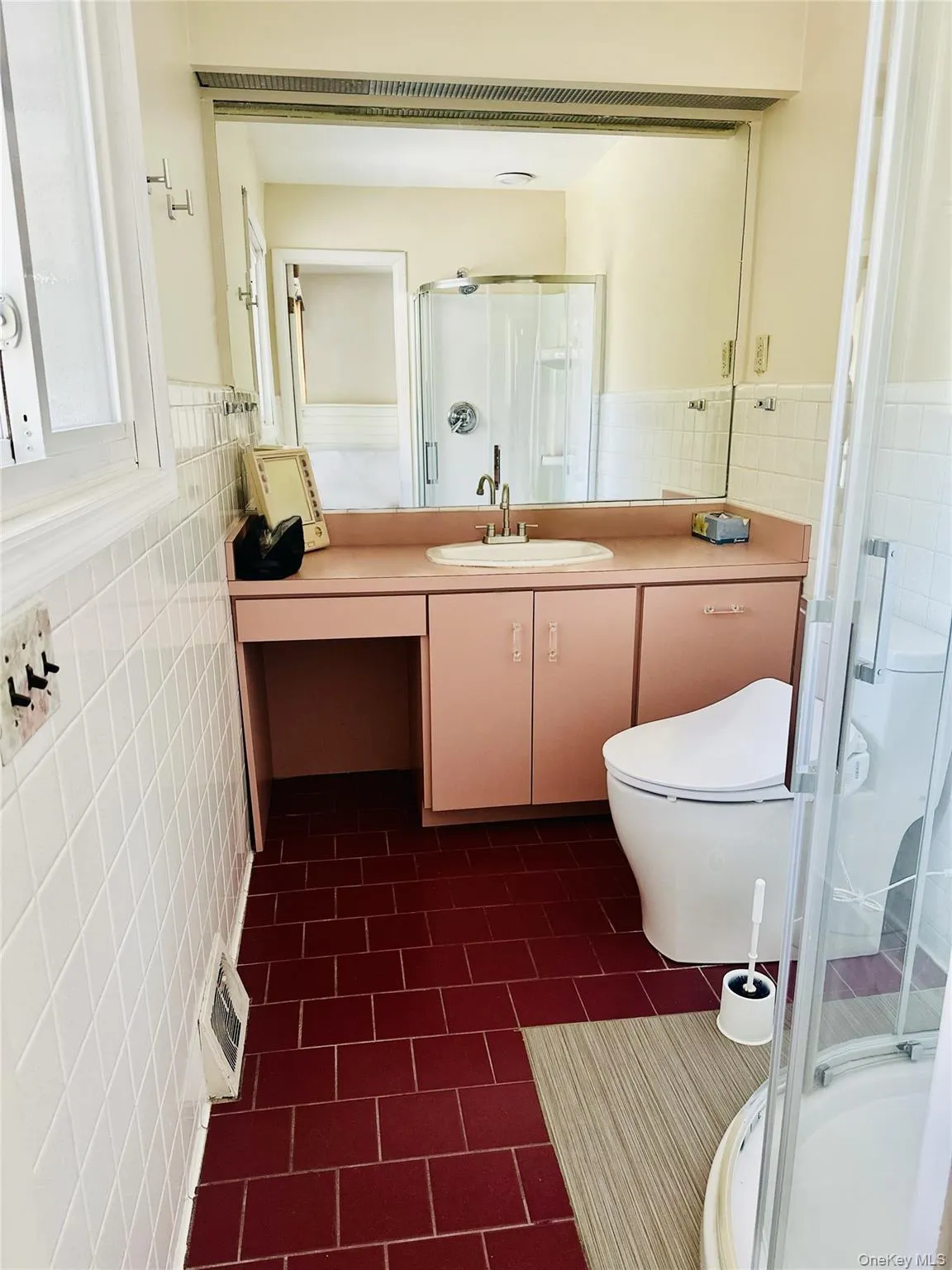 Bathroom with toilet, vanity, tile walls, and walk in shower Bathroom with toilet, vanity, tile walls, and walk in shower