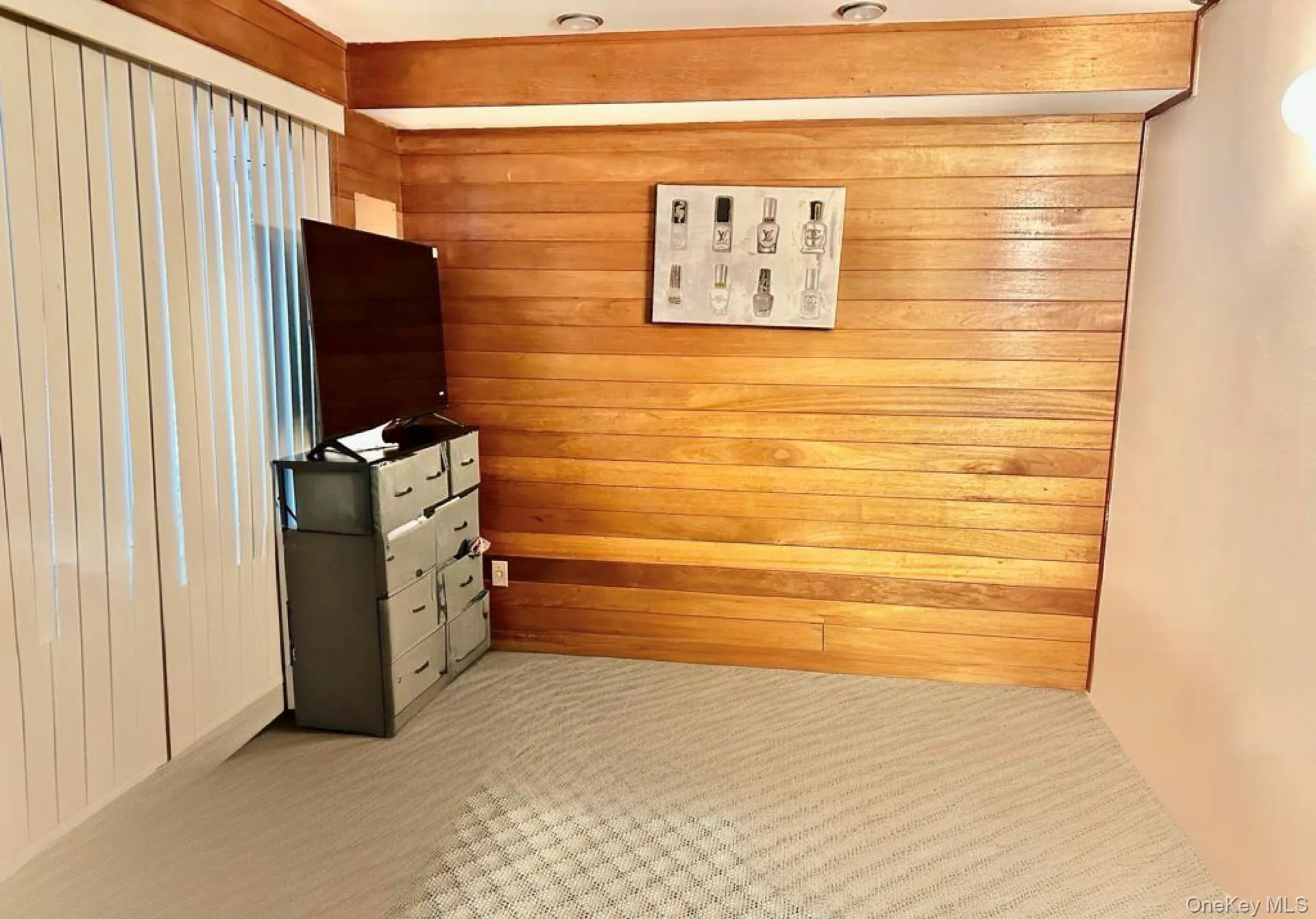 Unfurnished bedroom with wood walls and light colored carpet Unfurnished bedroom with wood walls and light colored carpet