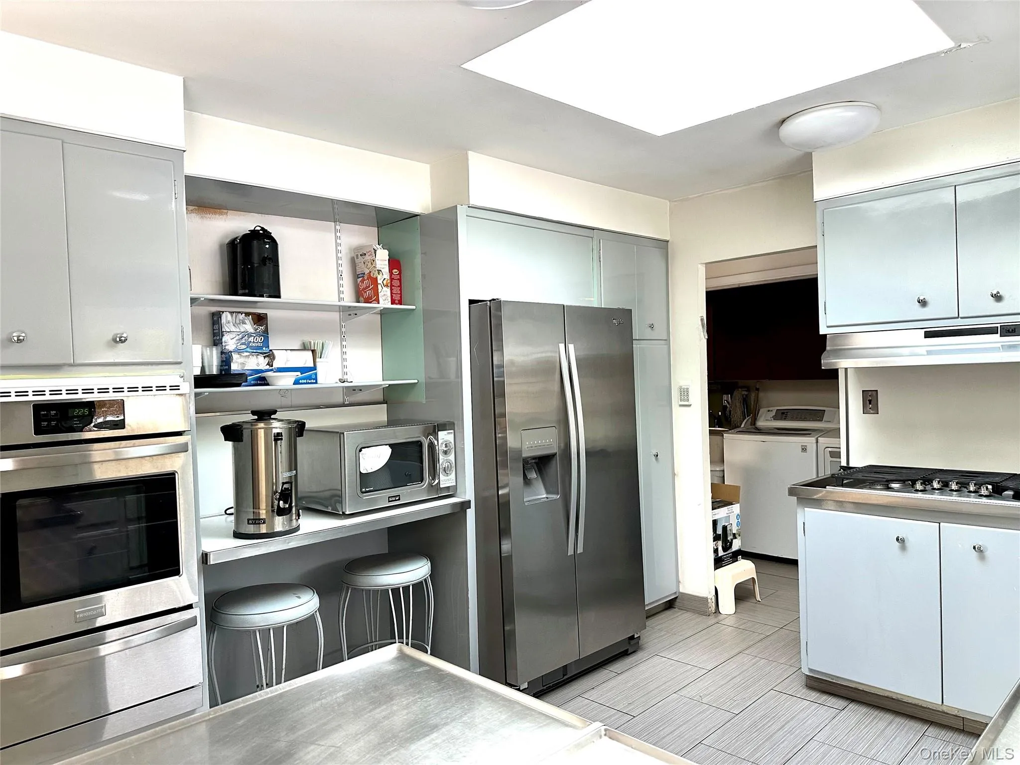Kitchen with separate washer and dryer and appliances with stainless steel finishes Kitchen with separate washer and dryer and appliances with stainless steel finishes