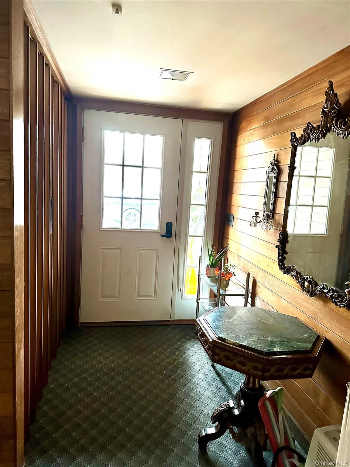 Doorway featuring wood walls and carpet floors Doorway featuring wood walls and carpet floors