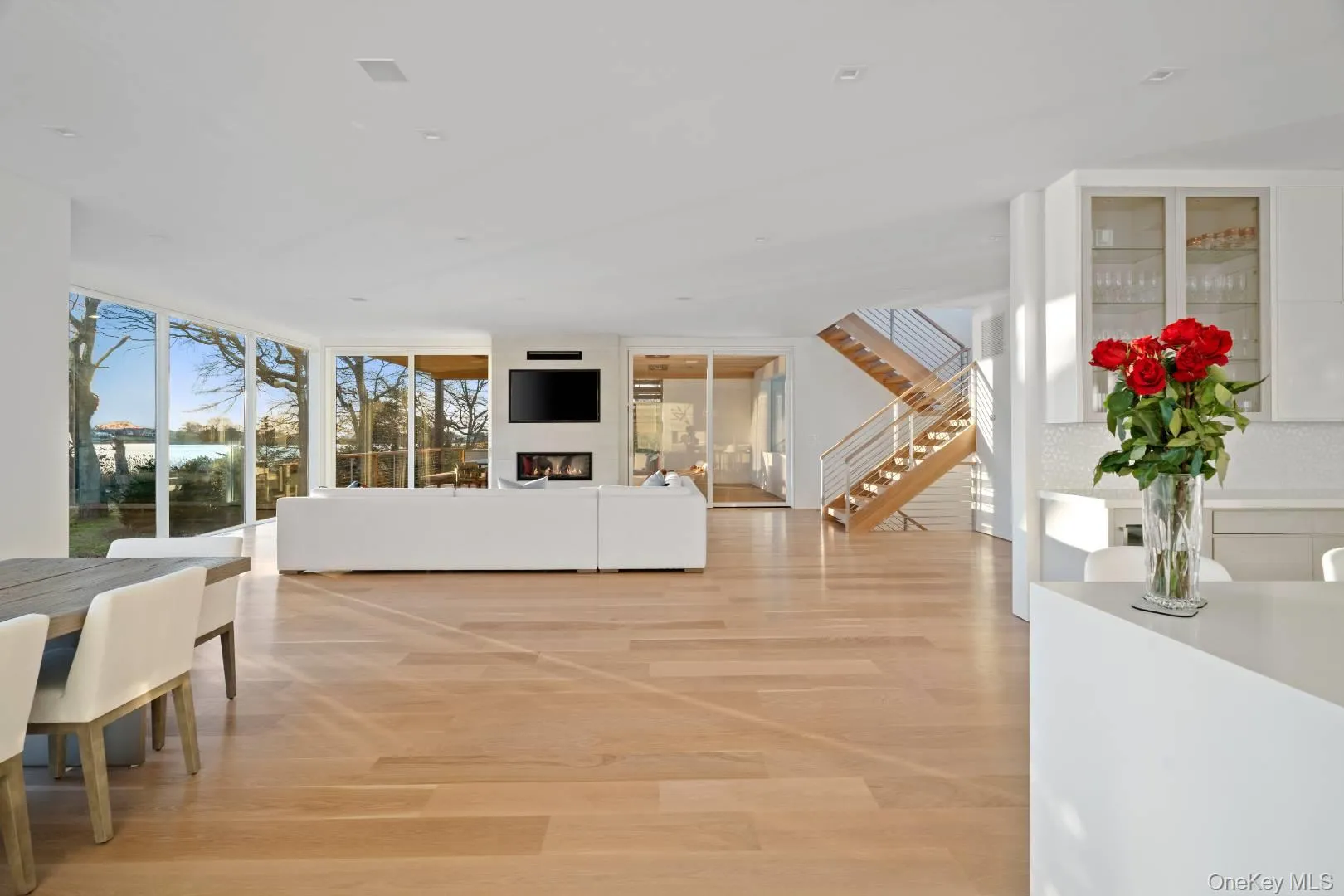 Living room featuring a wall of windows and light wood-type flooring Living room featuring a wall of windows and light wood-type flooring