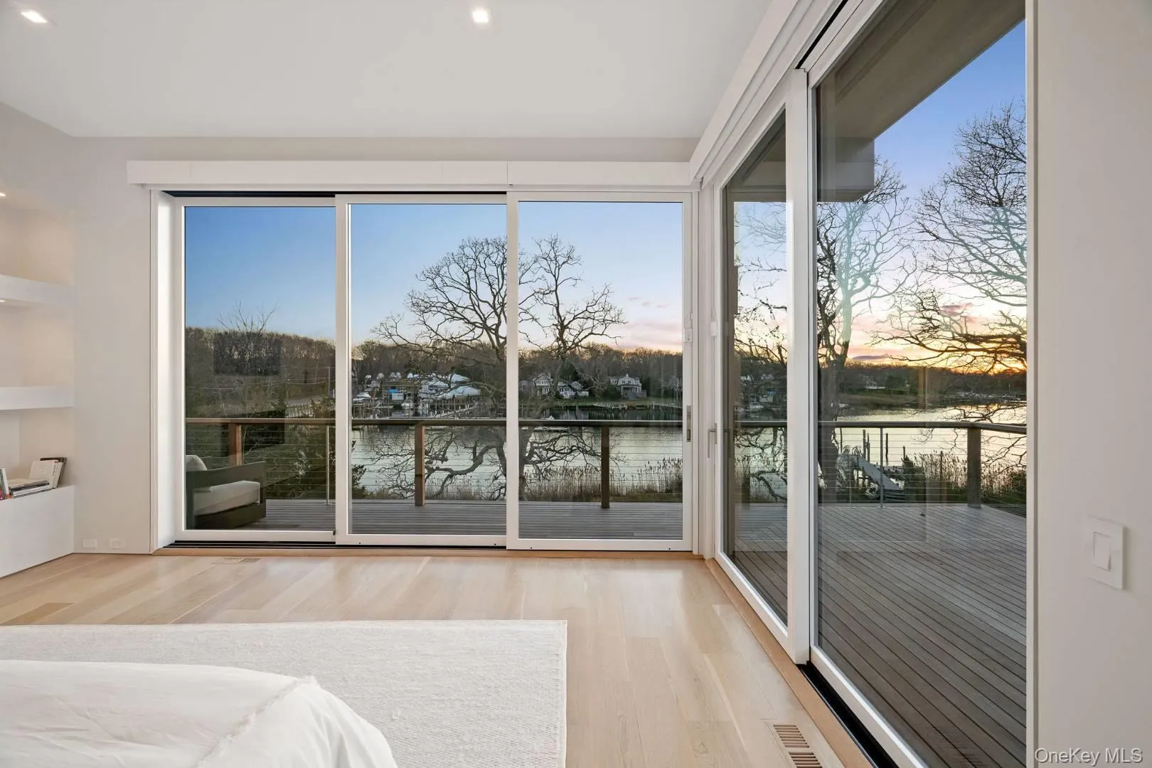 Unfurnished bedroom with access to outside, a water view, and light hardwood / wood-style floors Unfurnished bedroom with access to outside, a water view, and light hardwood / wood-style floors