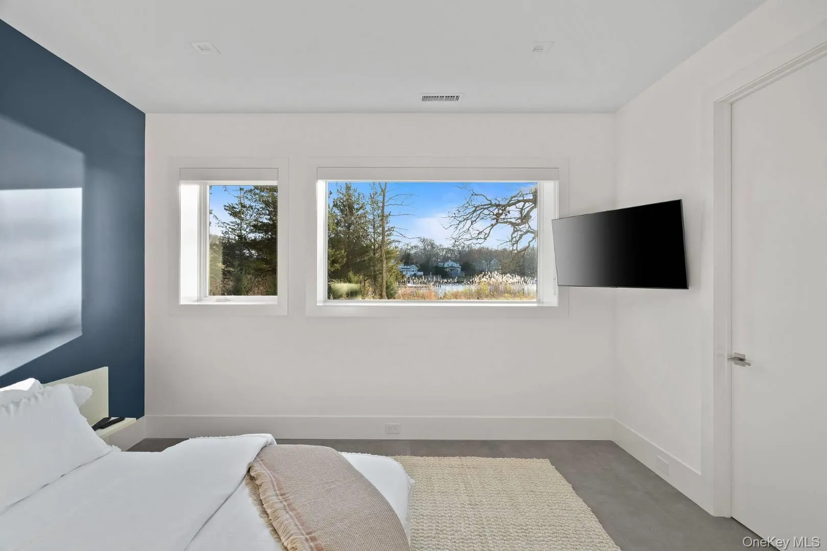 Bedroom with concrete floors and multiple windows Bedroom with concrete floors and multiple windows
