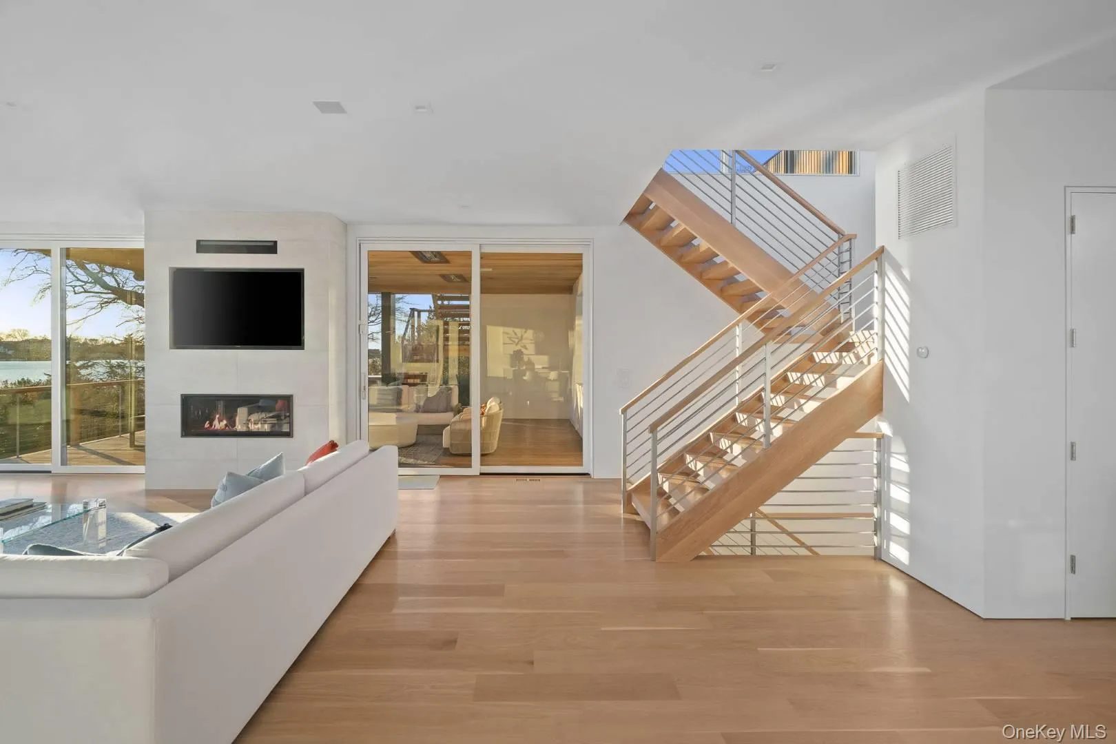 Living room featuring a fireplace, light hardwood / wood-style flooring, and a wall of windows Living room featuring a fireplace, light hardwood / wood-style flooring, and a wall of windows
