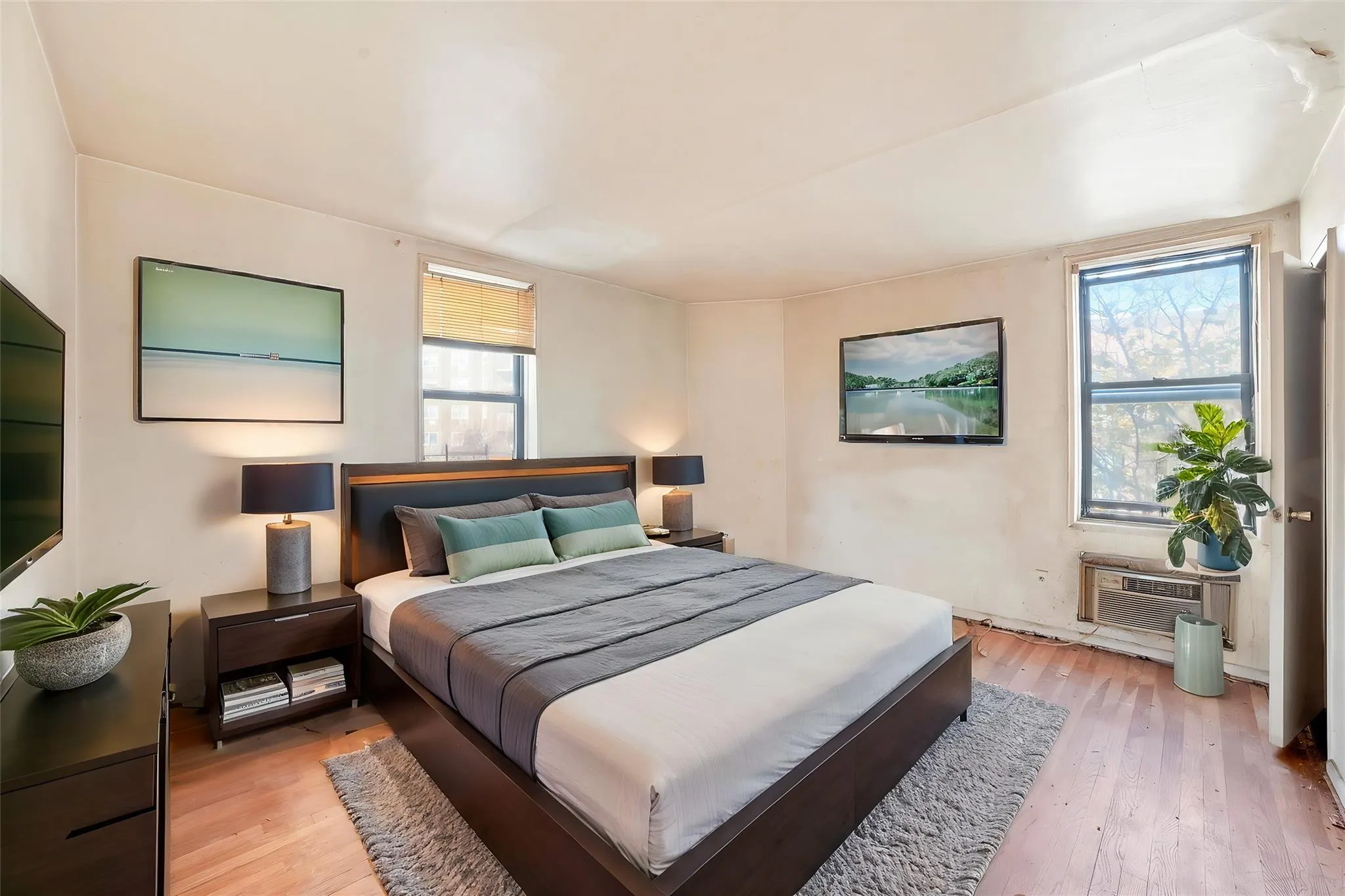 Bedroom featuring light wood-type flooring and a wall mounted AC Bedroom featuring light wood-type flooring and a wall mounted AC