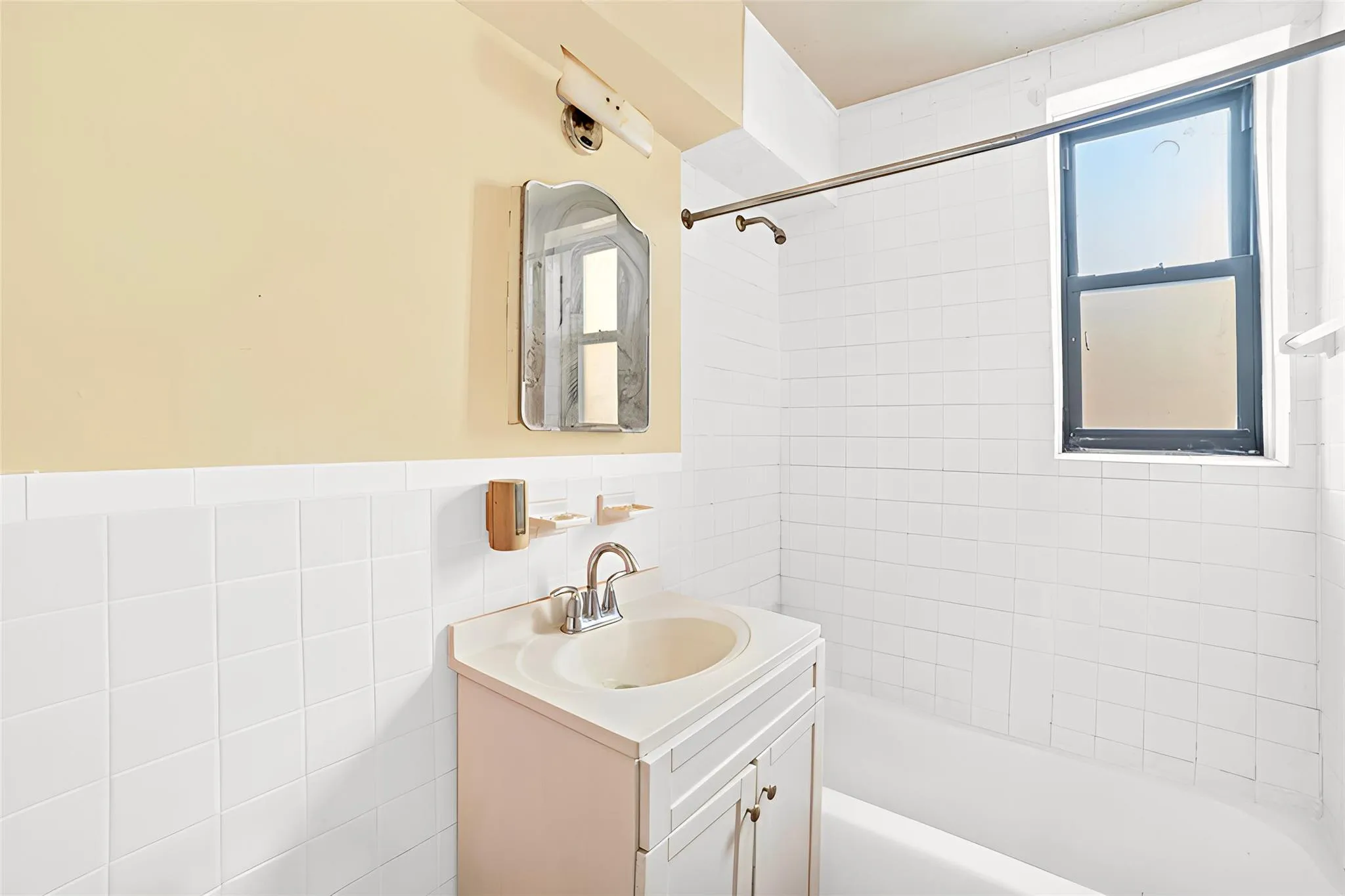 *Virtually Staged Bathroom featuring tile walls, vanity, and tiled shower / bath *Virtually Staged Bathroom featuring tile walls, vanity, and tiled shower / bath