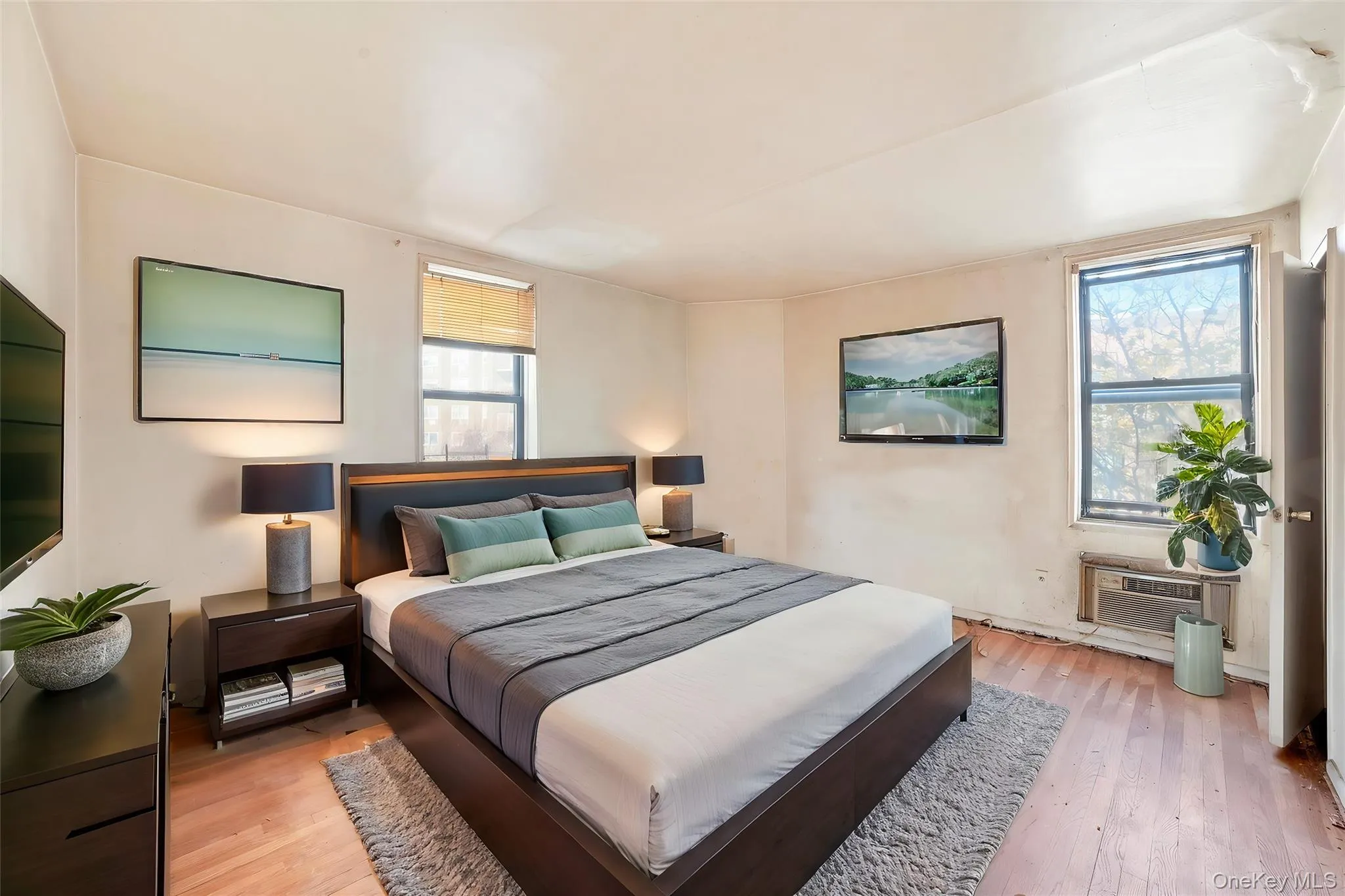 Bedroom featuring light wood-type flooring and a wall mounted AC Bedroom featuring light wood-type flooring and a wall mounted AC