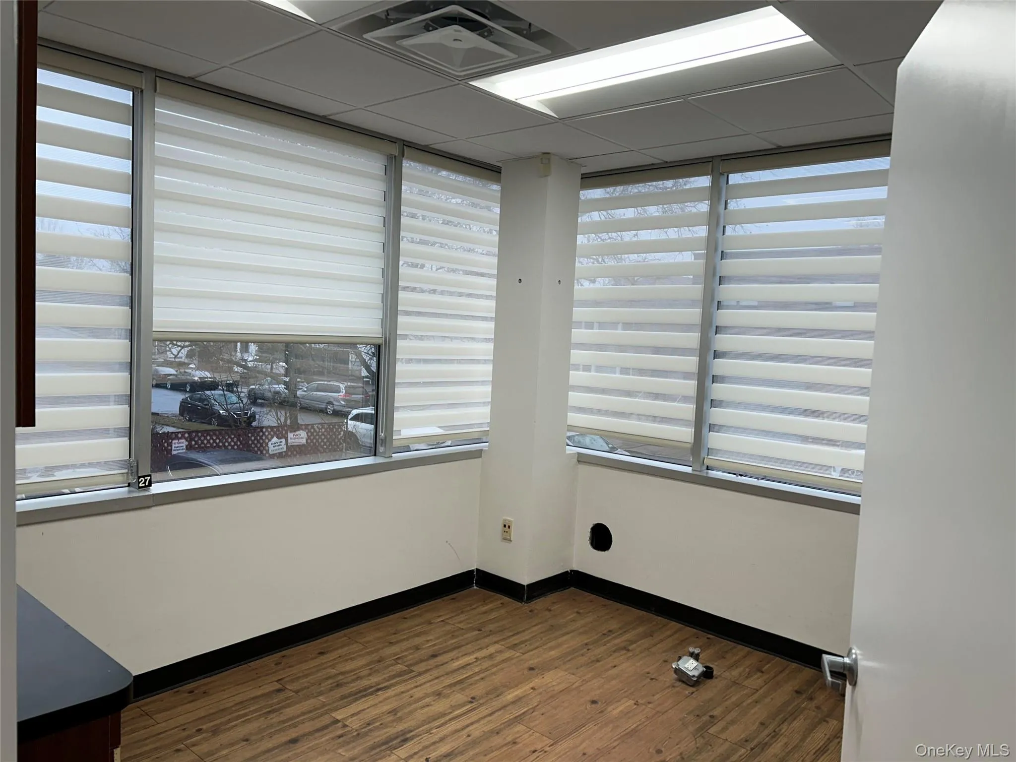 Spare room with hardwood / wood-style flooring, plenty of natural light, and a drop ceiling Spare room with hardwood / wood-style flooring, plenty of natural light, and a drop ceiling