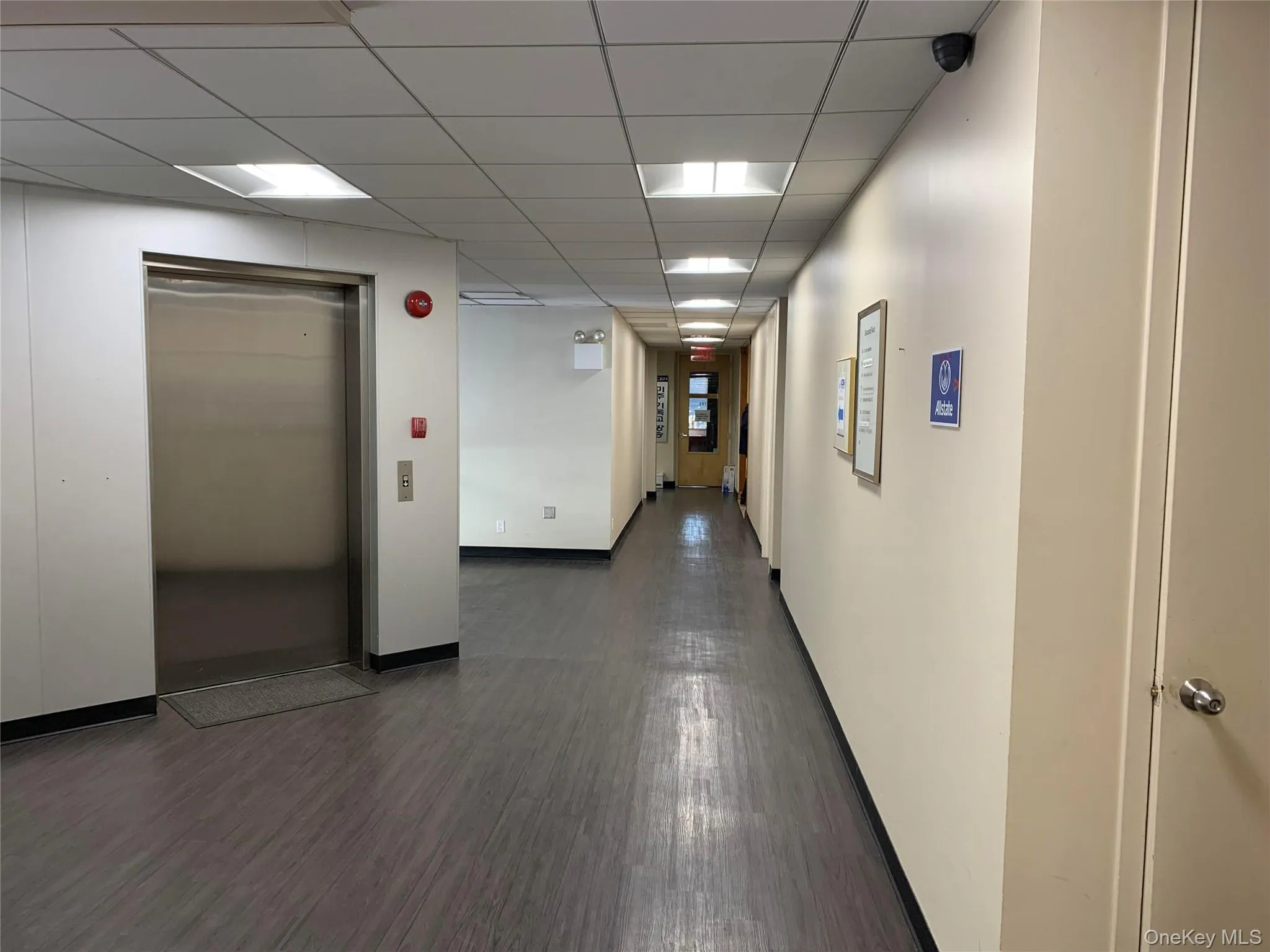 Hallway with dark hardwood / wood-style flooring and elevator Hallway with dark hardwood / wood-style flooring and elevator