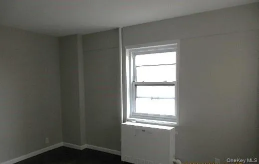 Empty room with radiator and a wealth of natural light Empty room with radiator and a wealth of natural light