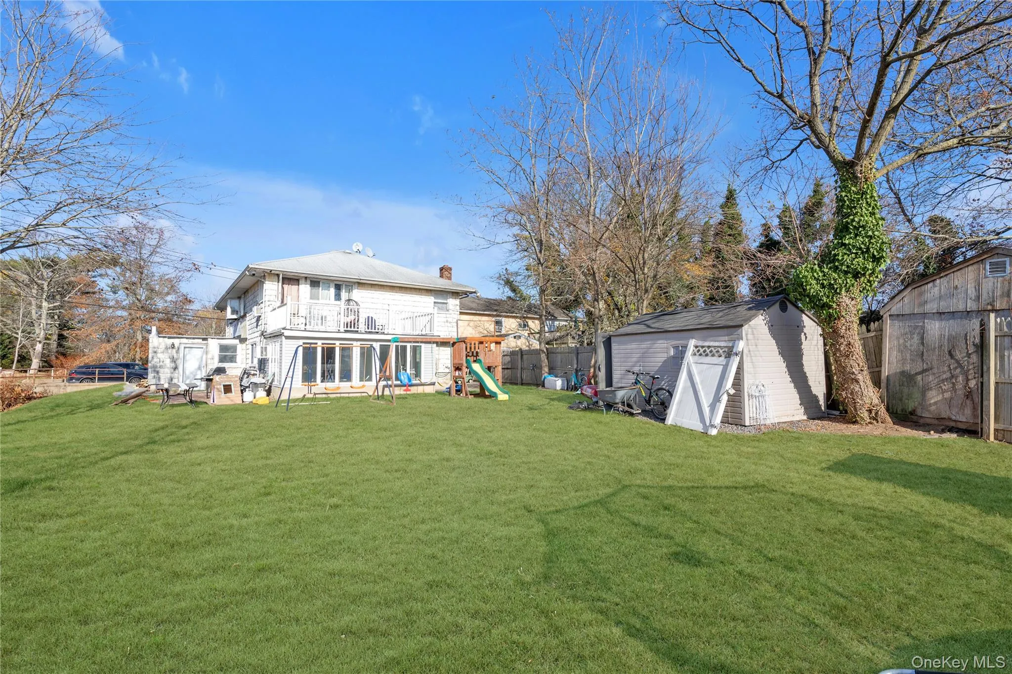 Rear view of property featuring a yard, a playground, and a storage shed Rear view of property featuring a yard, a playground, and a storage shed