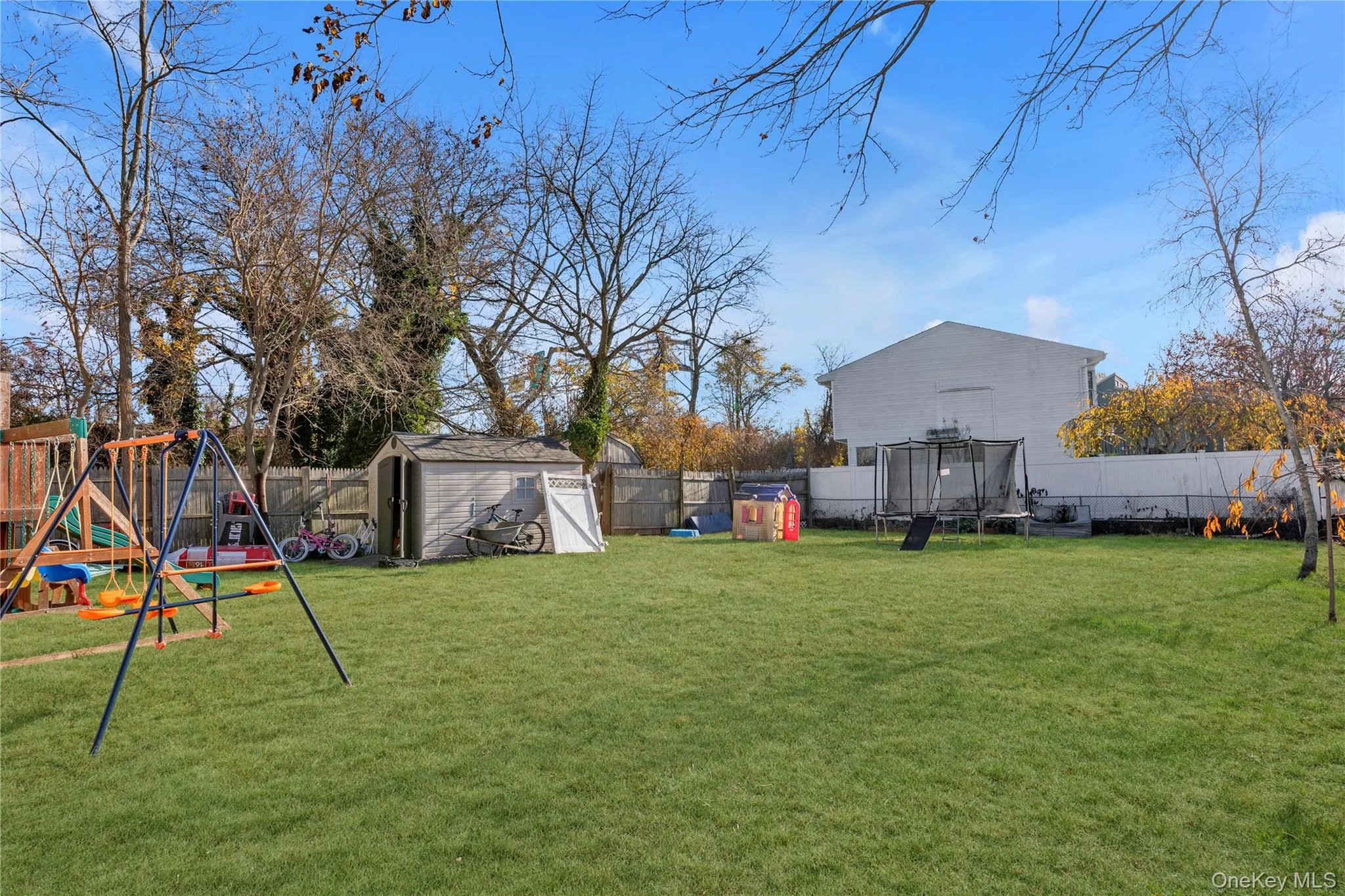 View of yard with a playground, a storage unit, and a trampoline View of yard with a playground, a storage unit, and a trampoline
