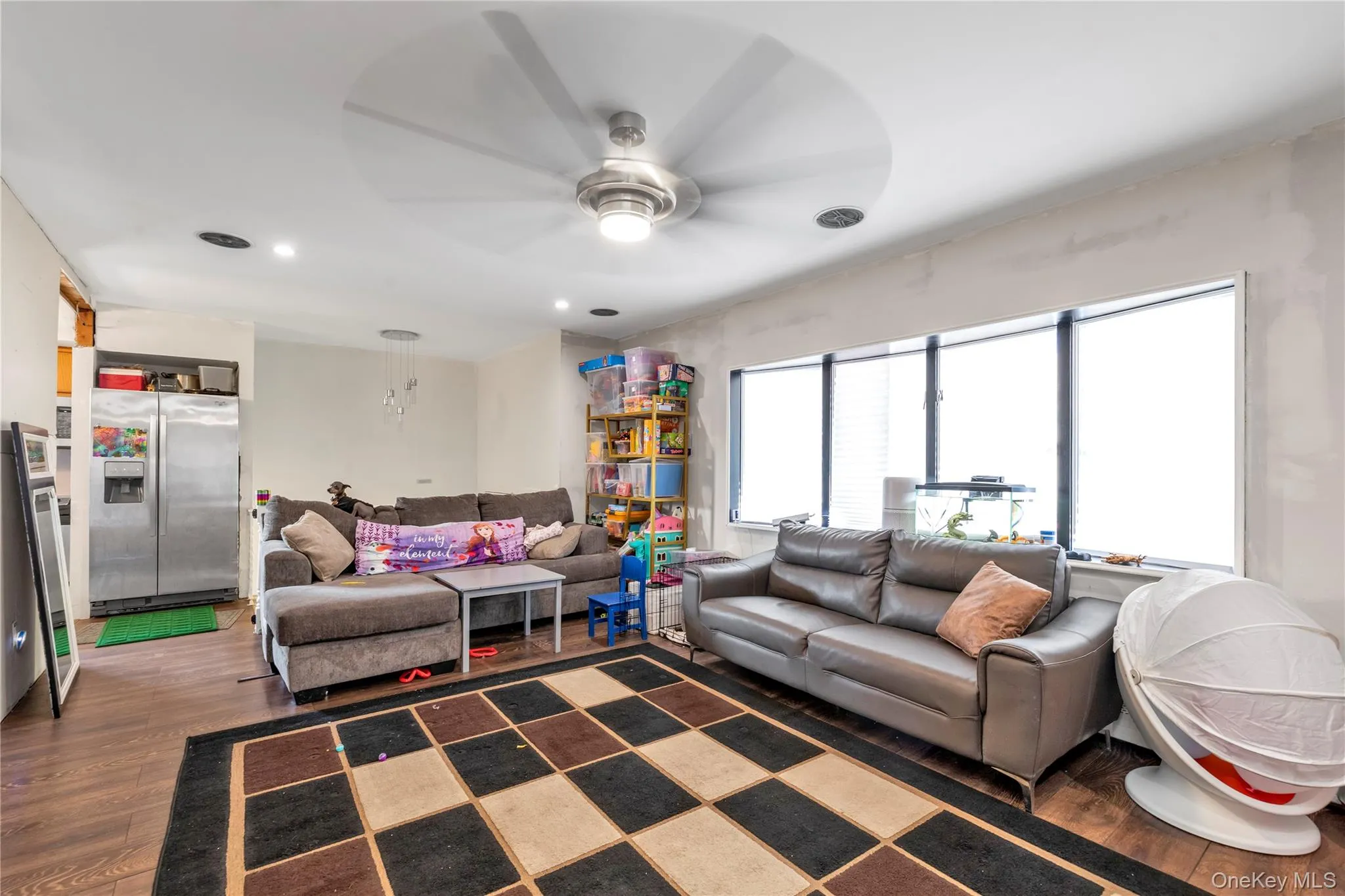 Living room with dark hardwood / wood-style floors and ceiling fan Living room with dark hardwood / wood-style floors and ceiling fan