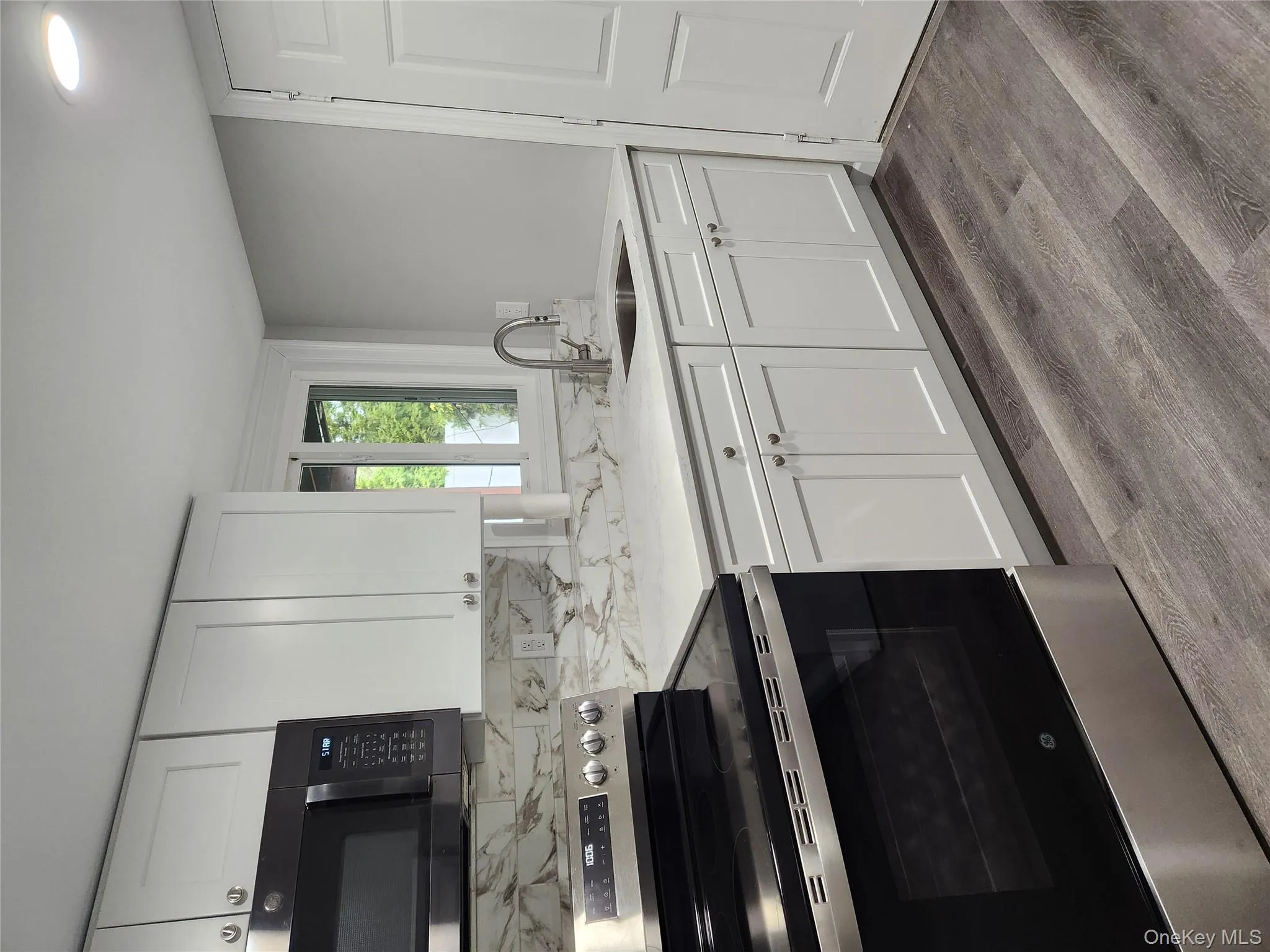 Kitchen with white cabinetry, stainless steel sink, and range Kitchen with white cabinetry, stainless steel sink, and range